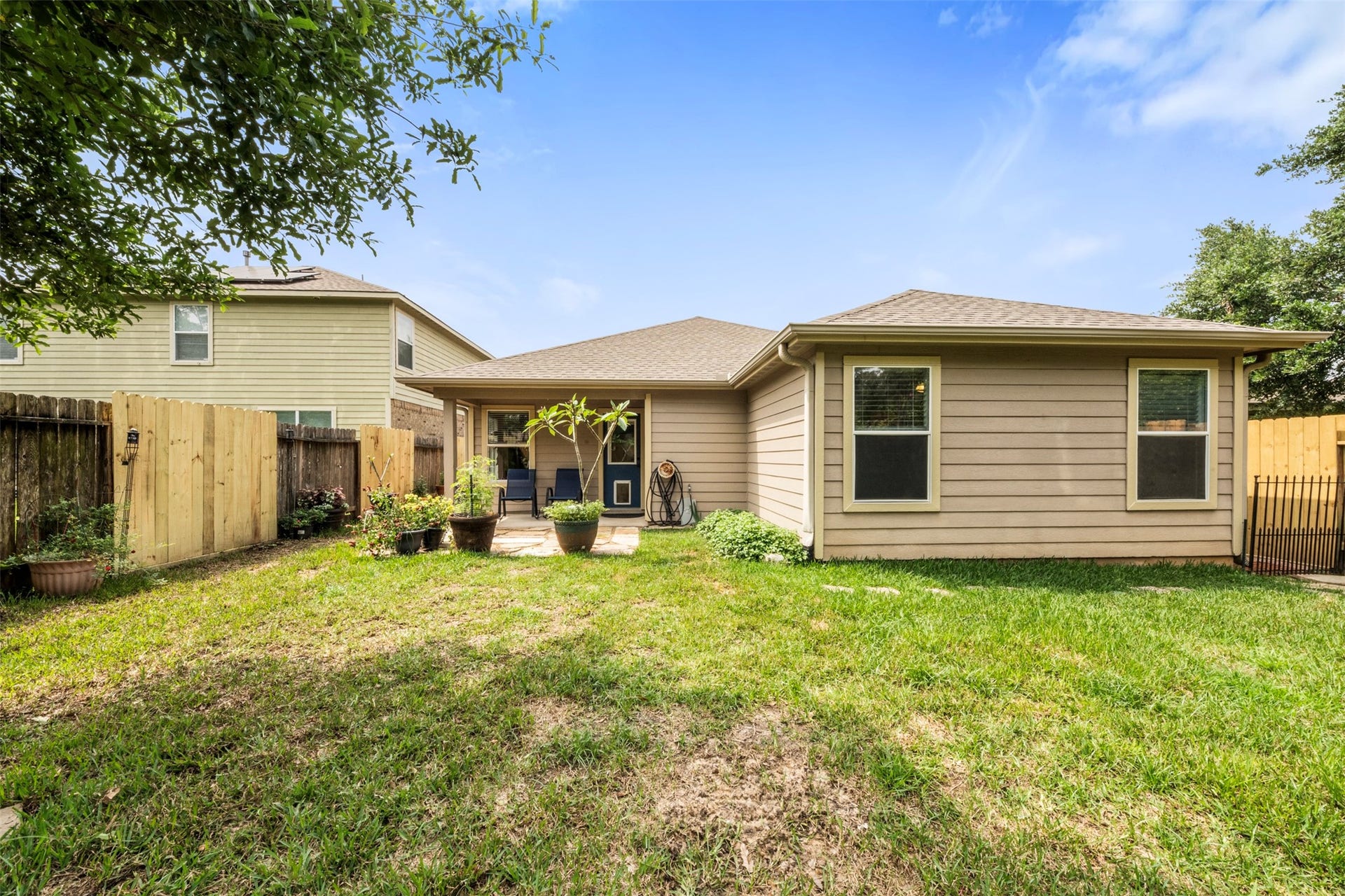 9750 Gulfstream Drive, Conroe, TX 77303 Backyard featuring a cozy patio area and a well-maintained lawn, perfect for outdoor relaxation. The space is enclosed with a wooden fence, offering privacy along with a touch of greenery.