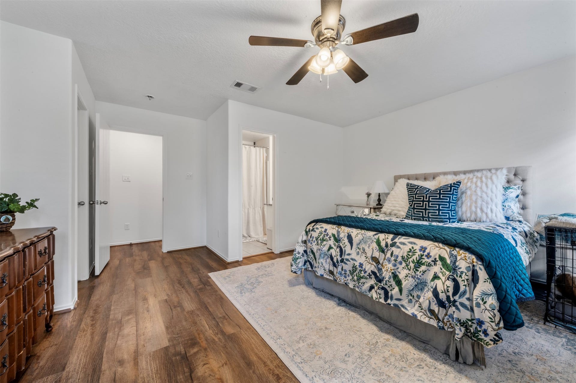 9750 Gulfstream Drive, Conroe, TX 77303 This spacious bedroom offers hardwood floors, a ceiling fan and abundant natural light, along with a private ensuite bathroom. Perfect for comfort and everyday living.