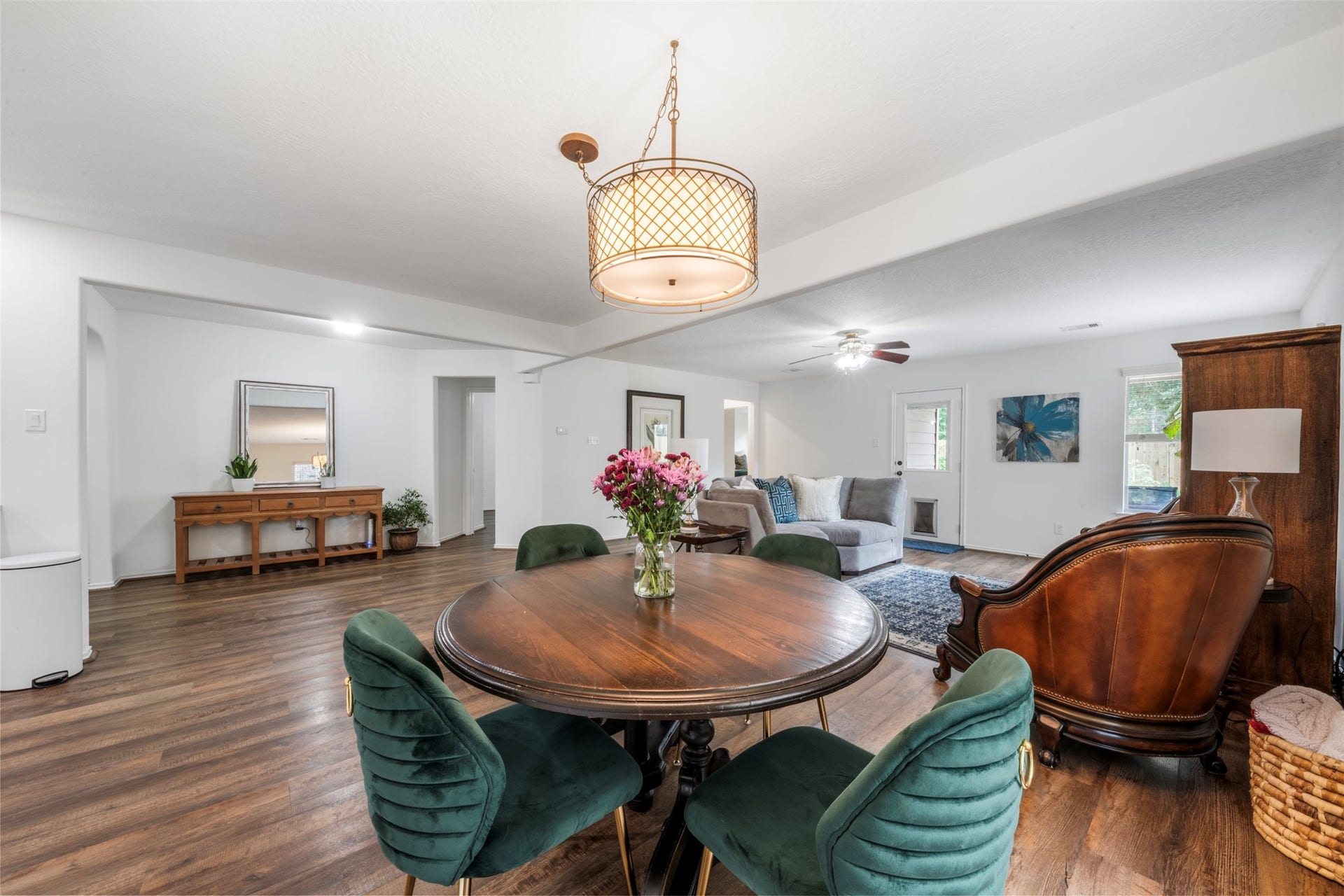 9750 Gulfstream Drive, Conroe, TX 77303 This inviting dining area features warm wood flooring and a stylish overhead light, with an adjacent cozy living space that creates a charming, cohesive look.