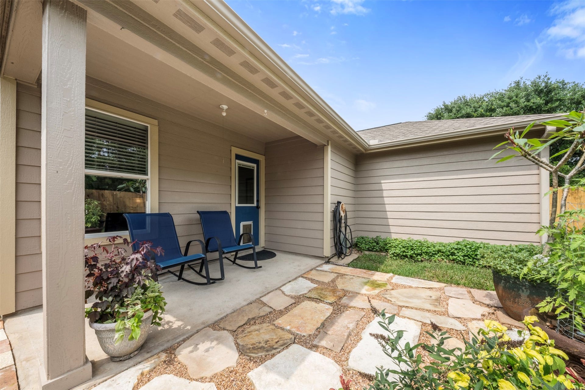 9750 Gulfstream Drive, Conroe, TX 77303 Relax in this charming covered patio area, complete with a stone pathway and lush greenery. An inviting outdoor space to enjoy quiet moments.