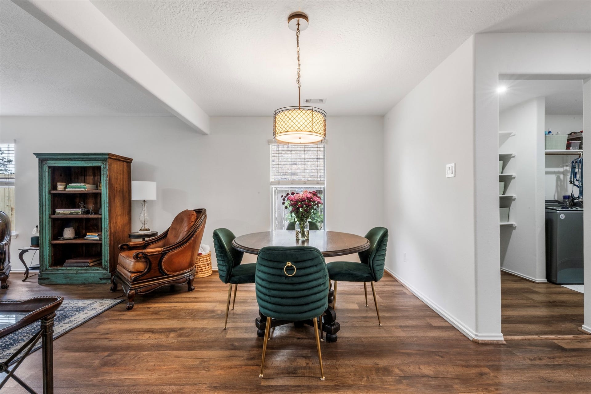 9750 Gulfstream Drive, Conroe, TX 77303 An inviting dining area showcases warm wood flooring and a stylish overhead light, flowing seamlessly into a cozy living space for a cohesive and welcoming feel.