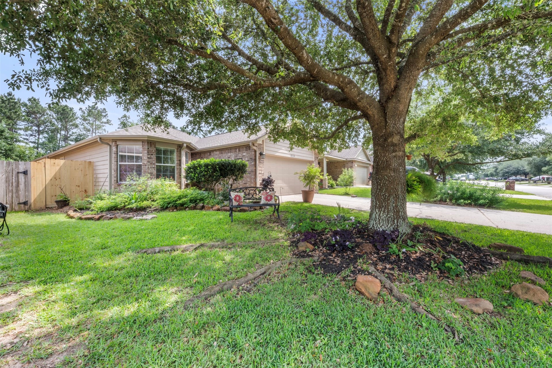 9750 Gulfstream Drive, Conroe, TX 77303 Enjoy the charm of this single-story home with a two-car garage, set against a backdrop of lush greenery. A mature shade tree and welcoming front yard create a peaceful, inviting entrance.