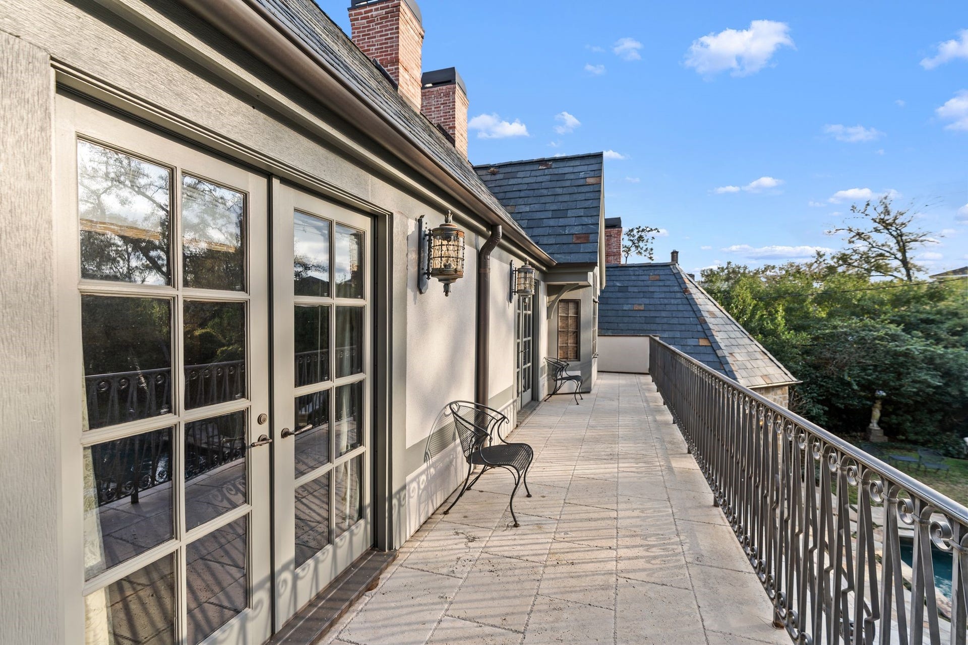 [ Primary Bedroom Balcony]
Reserved for the primary bedroom, this wide stone balcony overlooks the patios and pool.