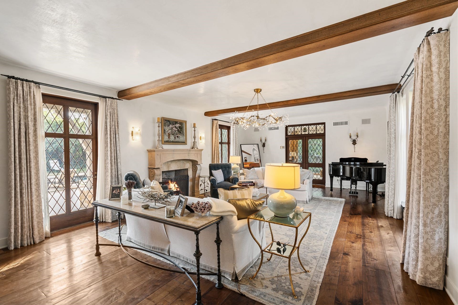 [Living Room]
Plaster walls and ceiling, box beams, and full-length leaded glass windows and doors enhance the living room. Windows and doors were custom made for the house by Hope's Glass of Jamestown, NY, founded 1912. Hope's Glass, still an active company, created identical reproductions for the sellers' later addition (per seller).