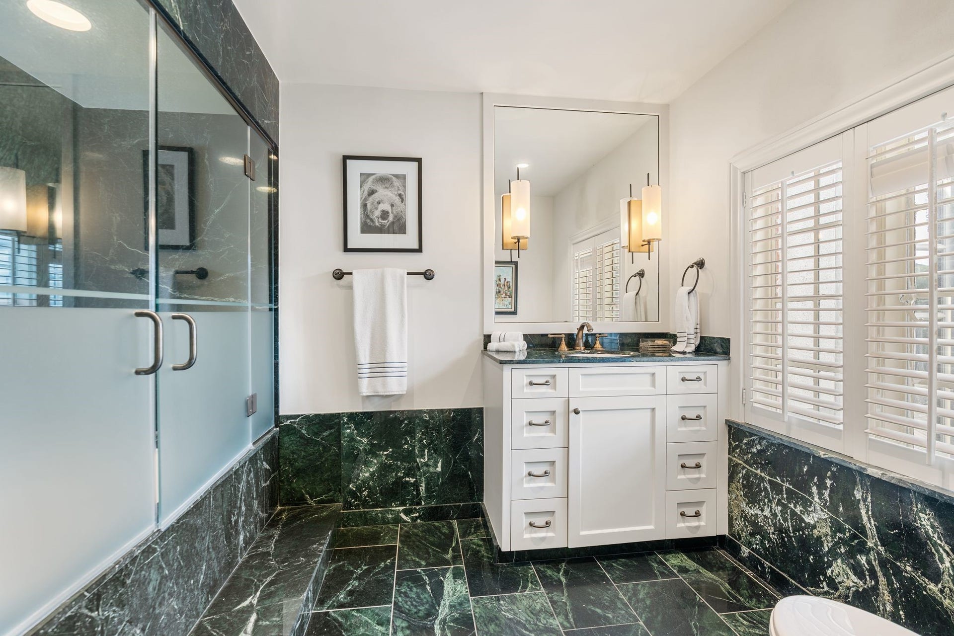 [En Suite Bath]
Malachite marble covers this en suite bath. Note opaque glass doors on jetted tub/shower.