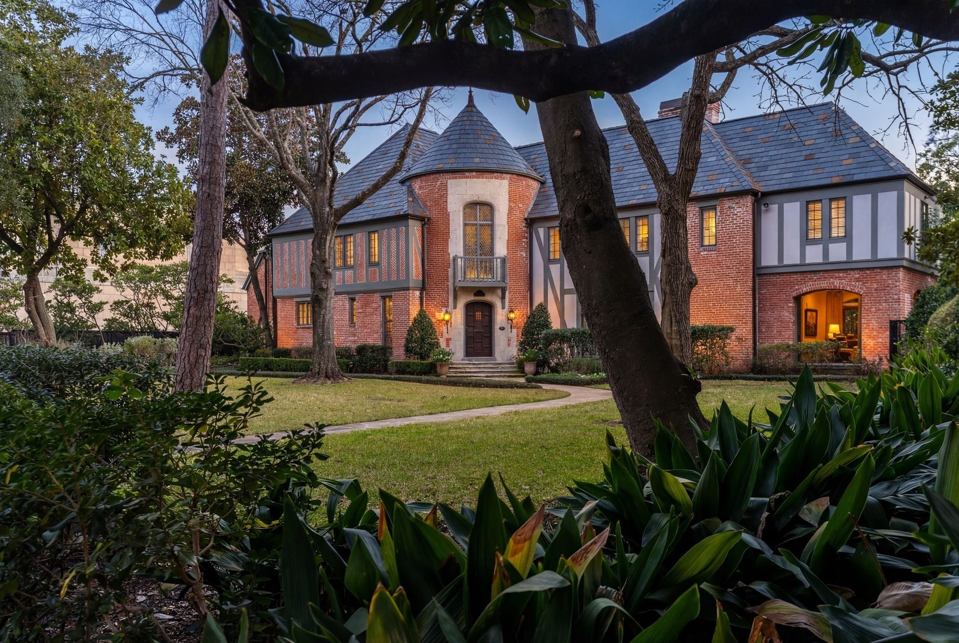 [Front Elevation]
A view of the front approach reveals a full-length arched window in the sunroom (right).
