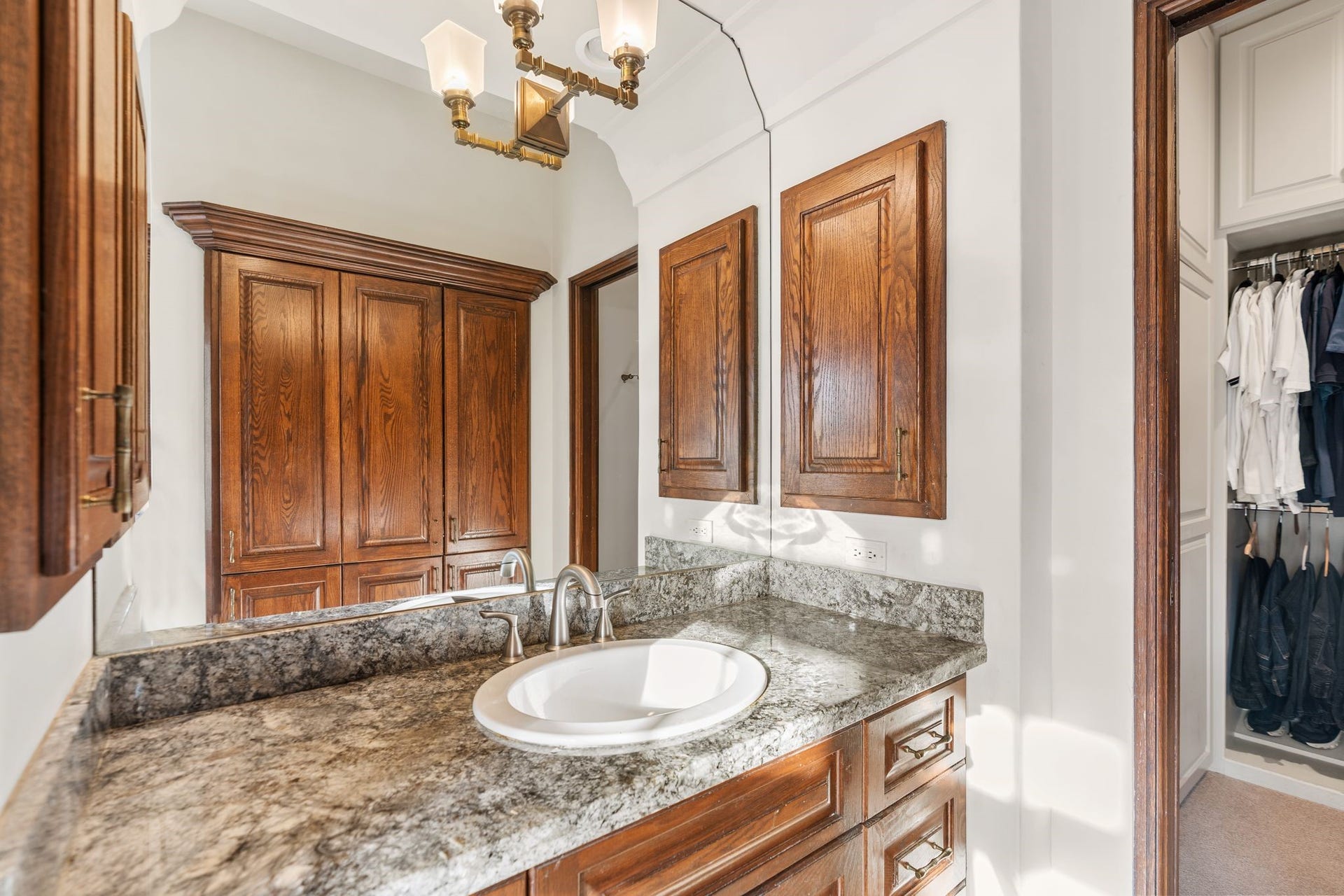 [Primary Bath #1]
Sink cabinet with stone deck and mirrored wall. Water closet (not shown) has a pocket door.