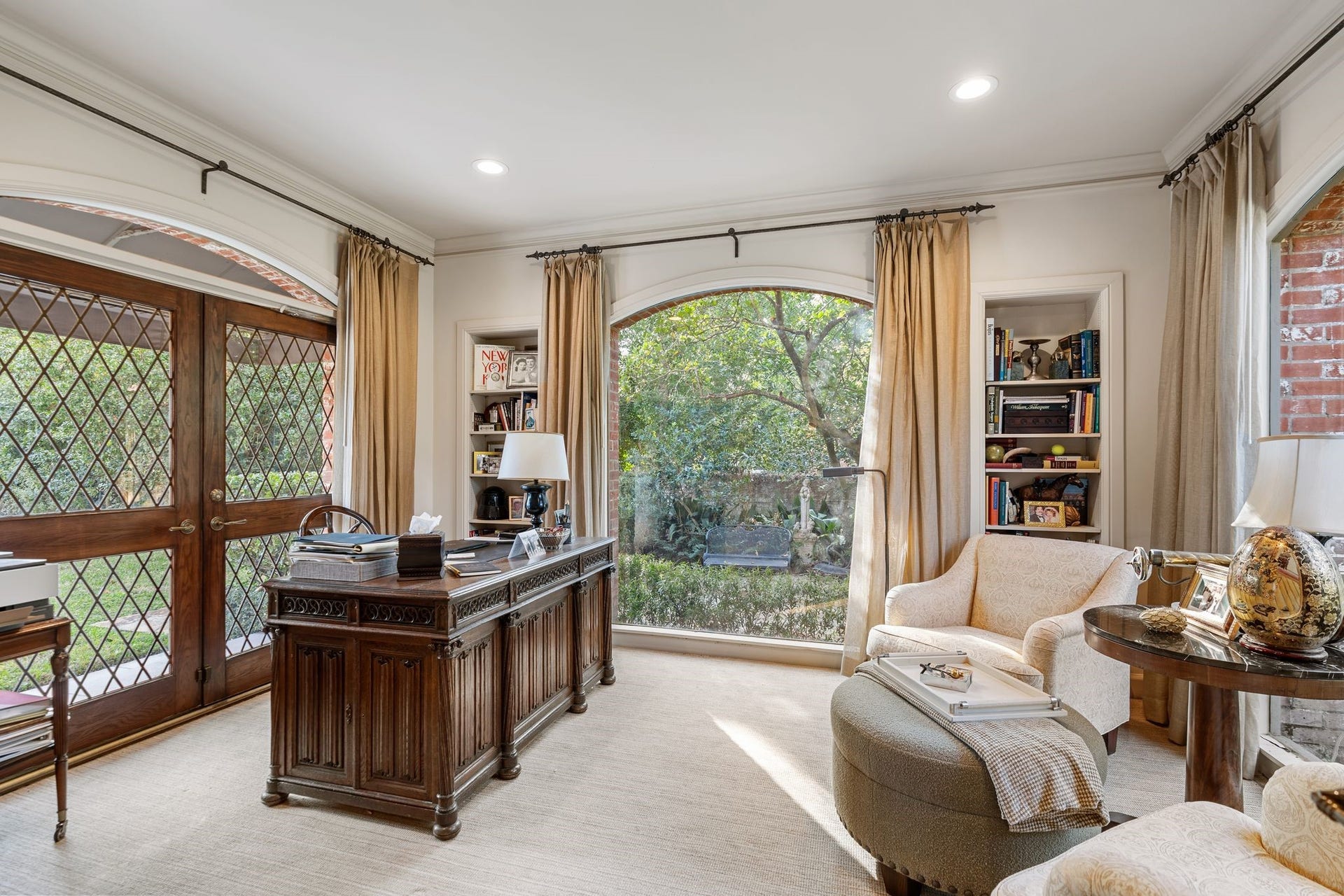 [Sunroom / Study / Library]
This light-filled space has a buffed brick floor, leaded glass exterior doors, and arched, full-length single-pane windows that provide patio, garden, and driveway views.