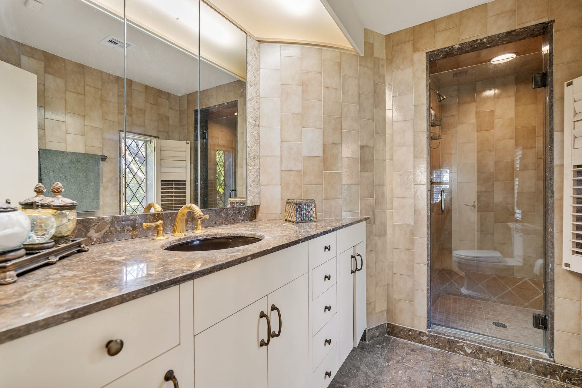 [En Suite Bath]
Stone sink deck, stone-tiled floor, and glass-entry shower with stone floor and wall.