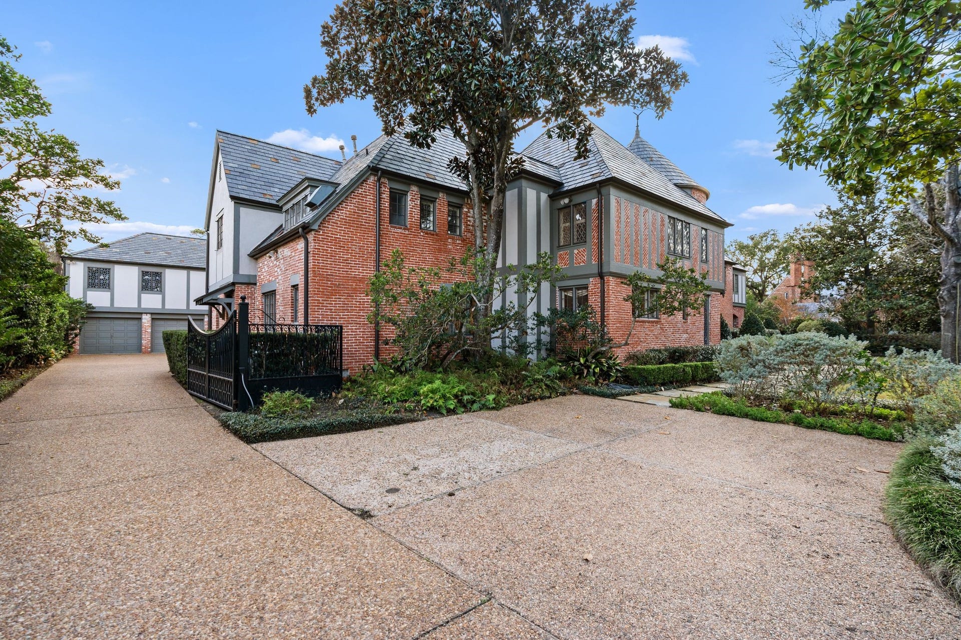 [Side Elevation]
This view travels along the gated driveway past a parking pad to the motor court and three-car garage.