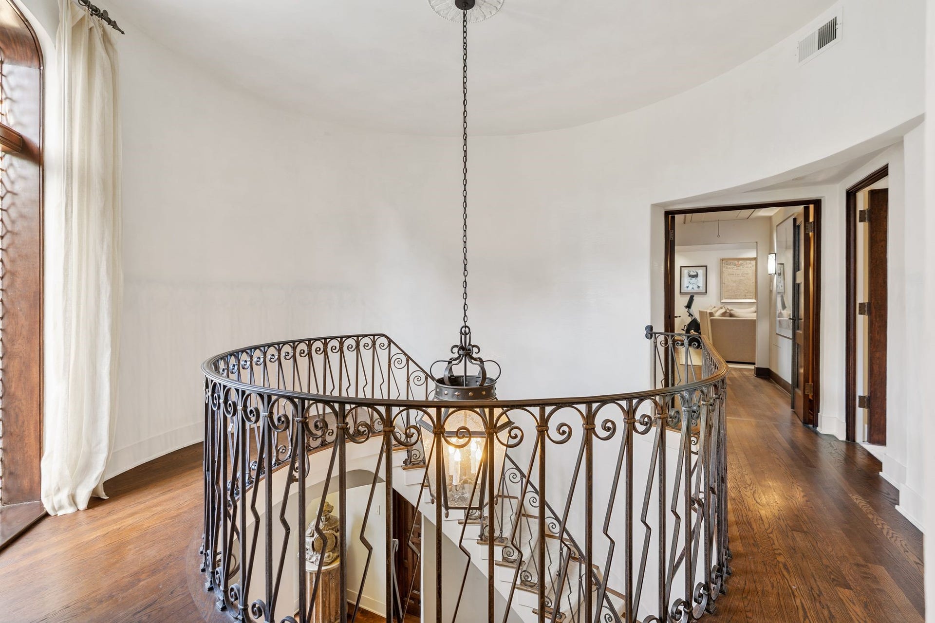 [Staircase Landing]
Rotunda landing; the arched, full-length, leaded glass window above the front door is at left. Secondary bedrooms join the landing and hall.