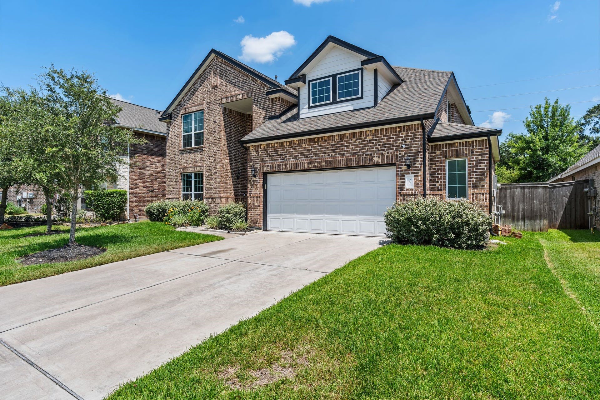 314 Arbor Ranch Circle, Richmond, TX 77469 Elegant exterior with two mature trees and a spacious driveway