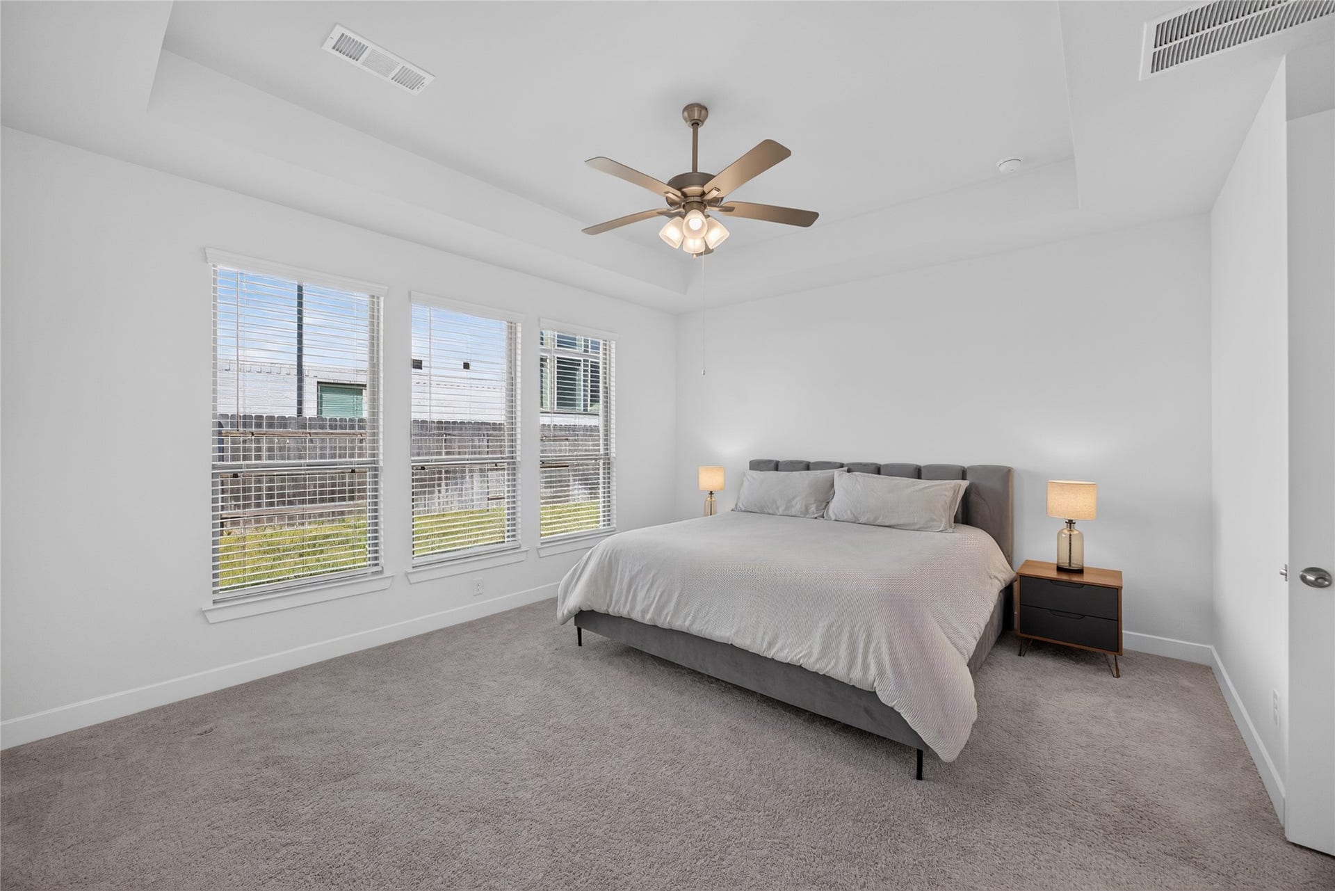 7311 Winding Aster Way, Katy, TX 77493 The first-floor primary bedroom offers a private retreat with a tray ceiling, ceiling fan and a broad bank of windows overlooking the backyard. Neutral walls and carpeting provide a versatile foundation for a variety of furnishings. The room offers space for a substantial bed and bedside pieces.