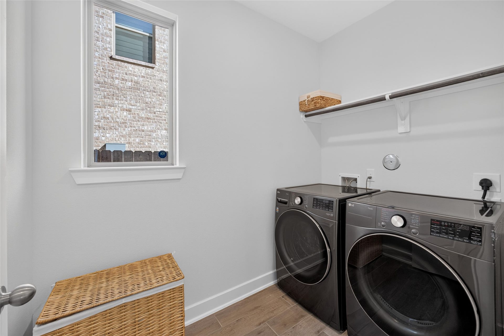 7311 Winding Aster Way, Katy, TX 77493 The dedicated laundry room provides space for side-by-side appliances and features a window that brings in natural light. An overhead shelf offers storage for laundry supplies, with a hanging rod below for air-drying or organizing clothing. The separate room keeps laundry tasks contained away from the main living spaces.
