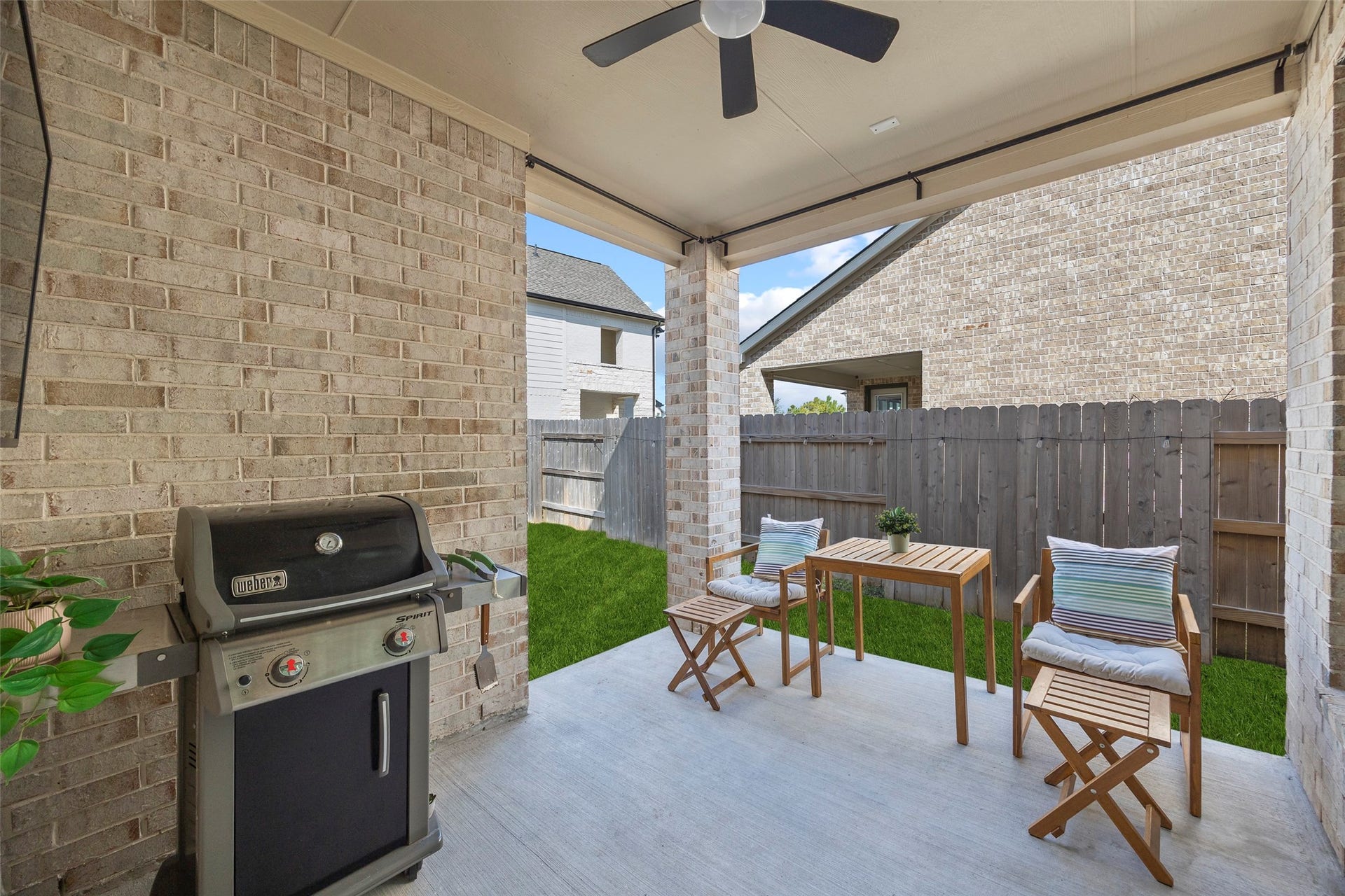 7311 Winding Aster Way, Katy, TX 77493 The covered patio offers a sheltered extension of the homes living space, with room for a small dining arrangement and grill setup. Brick walls and columns complement the exterior, while a ceiling fan helps circulate air. The patio opens directly to the lawn for convenient indoor-outdoor gatherings.