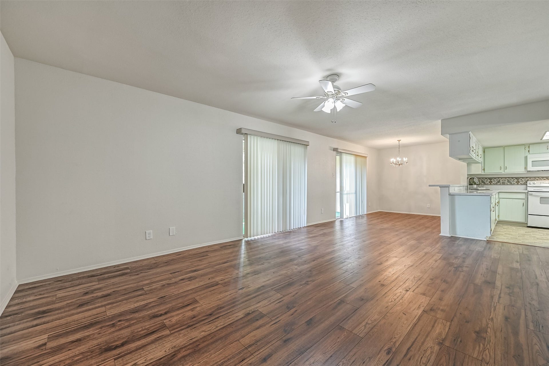 5005 Georgi Lane, #155, Houston, TX 77092 Looking across the main living areas, you'll appreciate the open floor plan, wood-look flooring & natural light filtering through the sliding glass doors. The living room flows into a separate dining space, with a breakfast bar connecting the kitchen to the rest of the home.