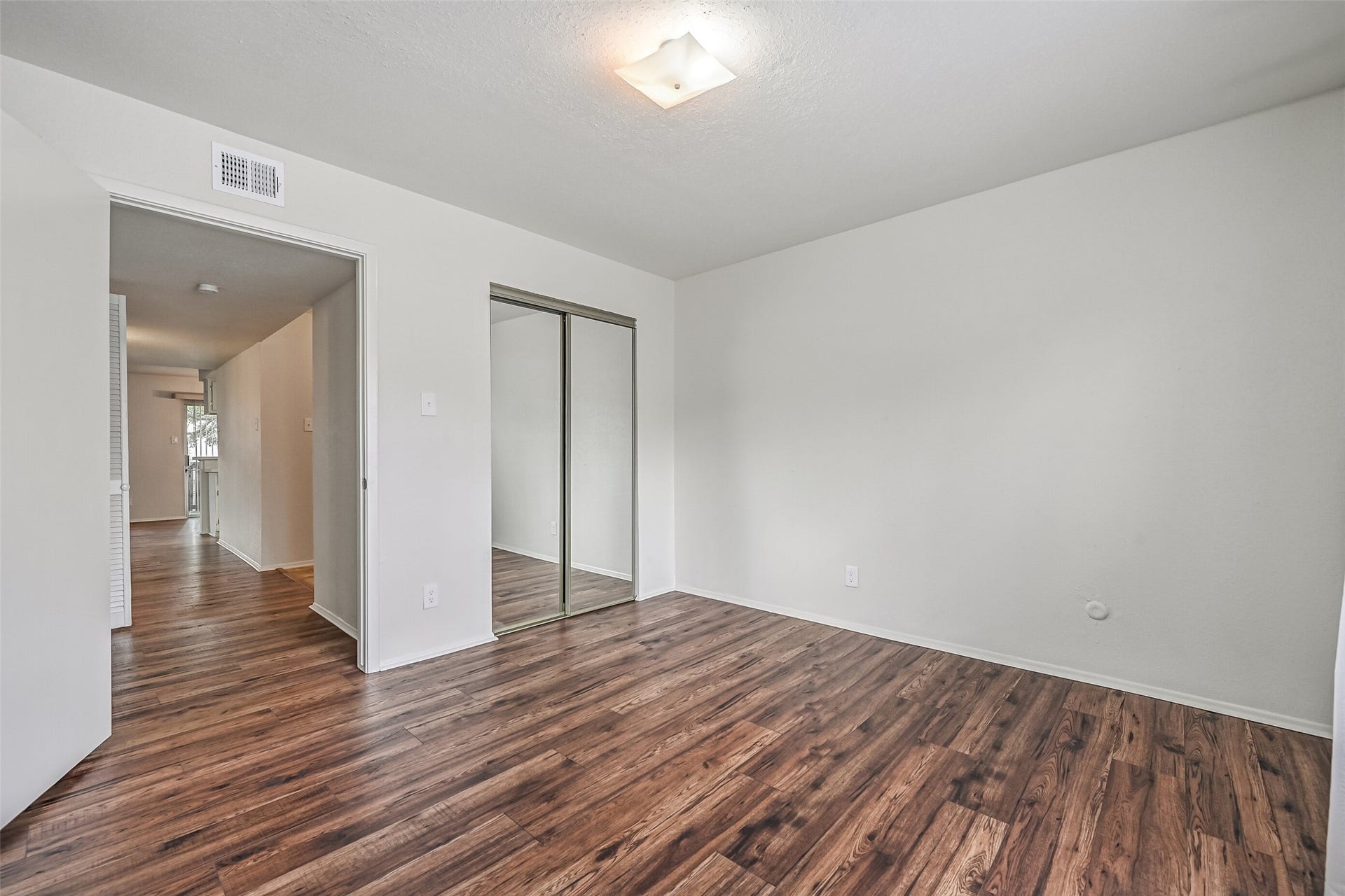 5005 Georgi Lane, #155, Houston, TX 77092 This secondary bedroom offers attractive wood-look flooring, neutral walls & a mirrored sliding-door closet that reflects light throughout the space. With room for bedroom furnishings and a versatile layout, this space could also serve as a home office or guest room.