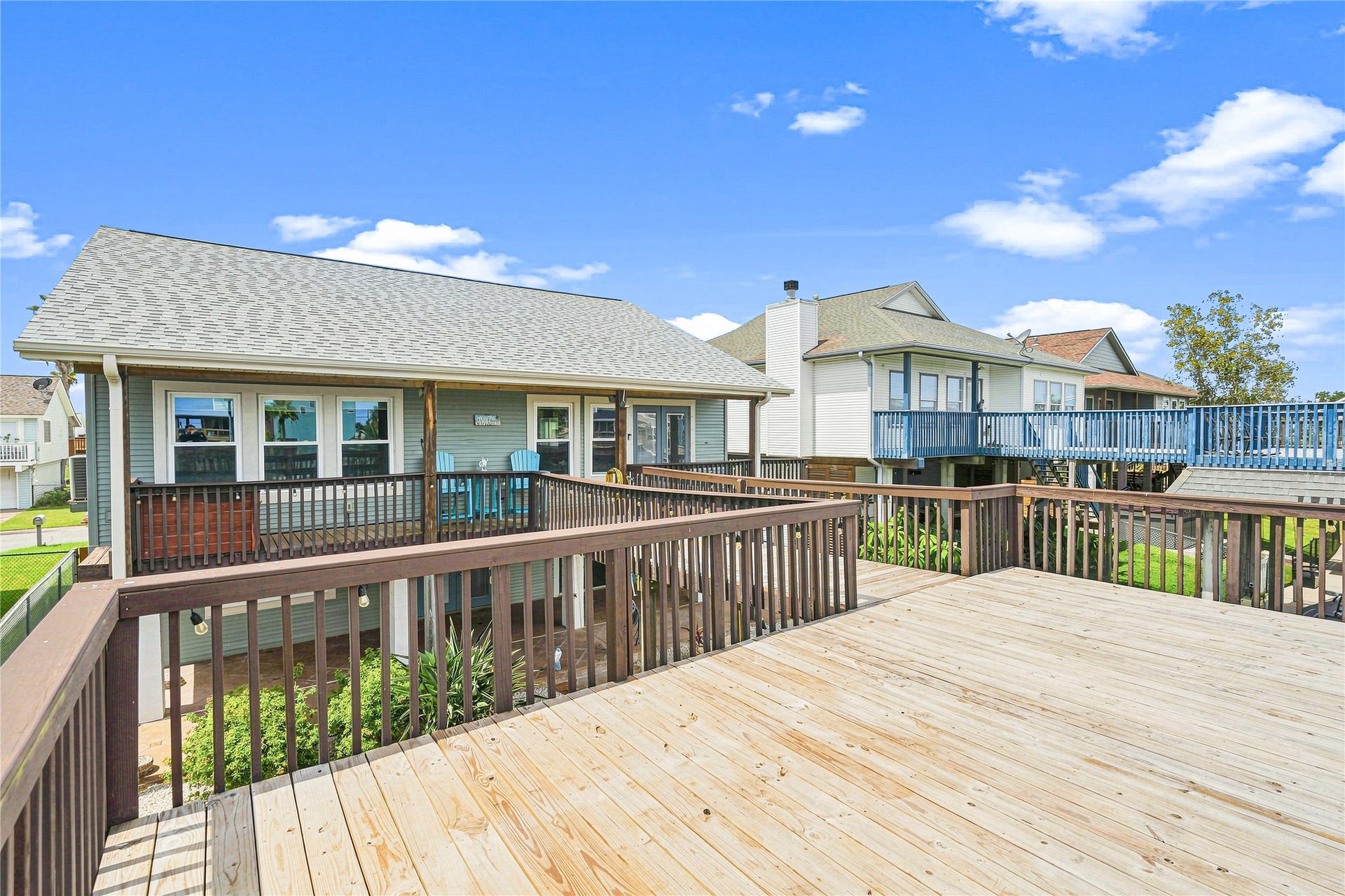 19 N Sandpiper Street, La Marque, TX 77568 Spacious elevated deck perfect for outdoor entertaining, with charming views of neighboring homes and a bright, inviting exterior.