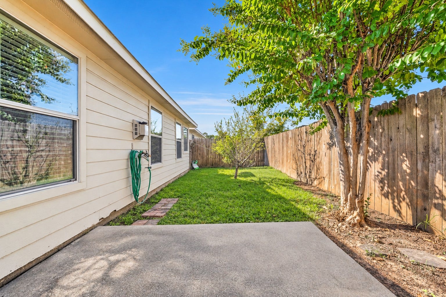 15835 Aldridge Creek Court, Cypress, TX 77429 Additional backyard view showcasing the patio, mature shade trees, and fully fenced outdoor space.