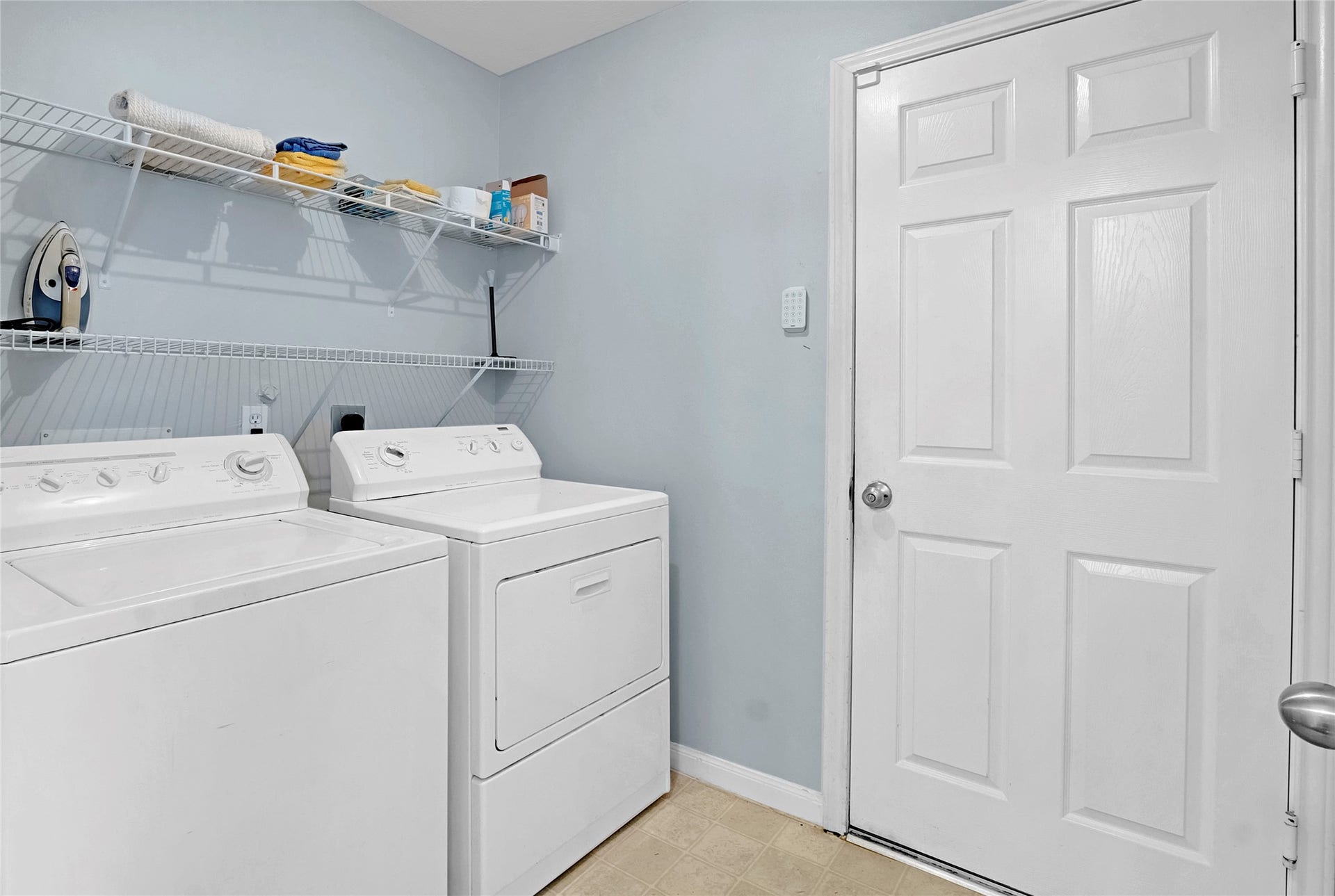 15835 Aldridge Creek Court, Cypress, TX 77429 Convenient laundry room with washer, dryer, and overhead storage shelving.