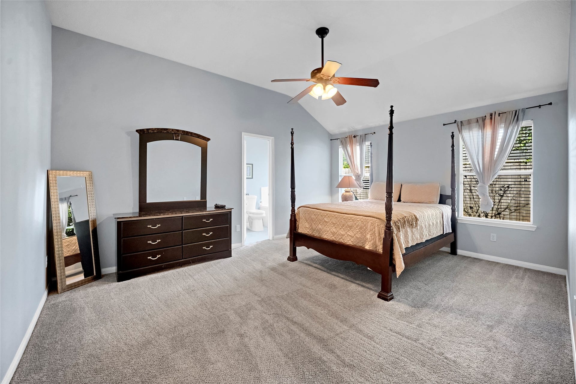15835 Aldridge Creek Court, Cypress, TX 77429 Spacious furnished primary bedroom with vaulted ceilings and an en-suite bathroom.