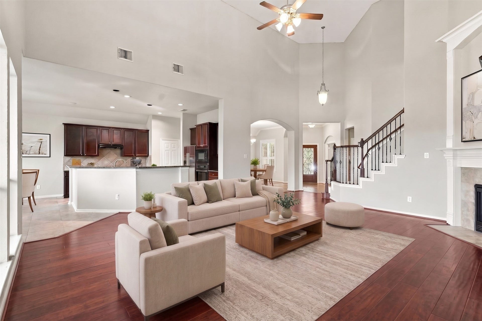 14226 Marin Drive, Cypress, TX 77429 Virtually Staged: Key features include soaring vertical height, a ceiling fan fixture, detailed wall arches, and rich wood floors that extend across the primary gathering space.