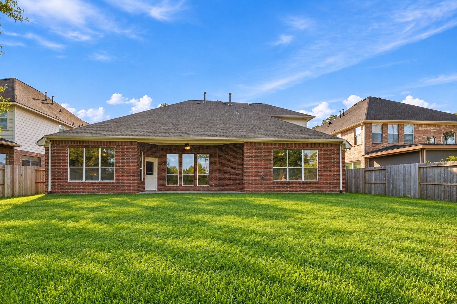 14226 Marin Drive, Cypress, TX 77429 The covered outdoor alcove and broad glass window panels highlight a functional outdoor area with immense space for relaxation or customized landscaping.