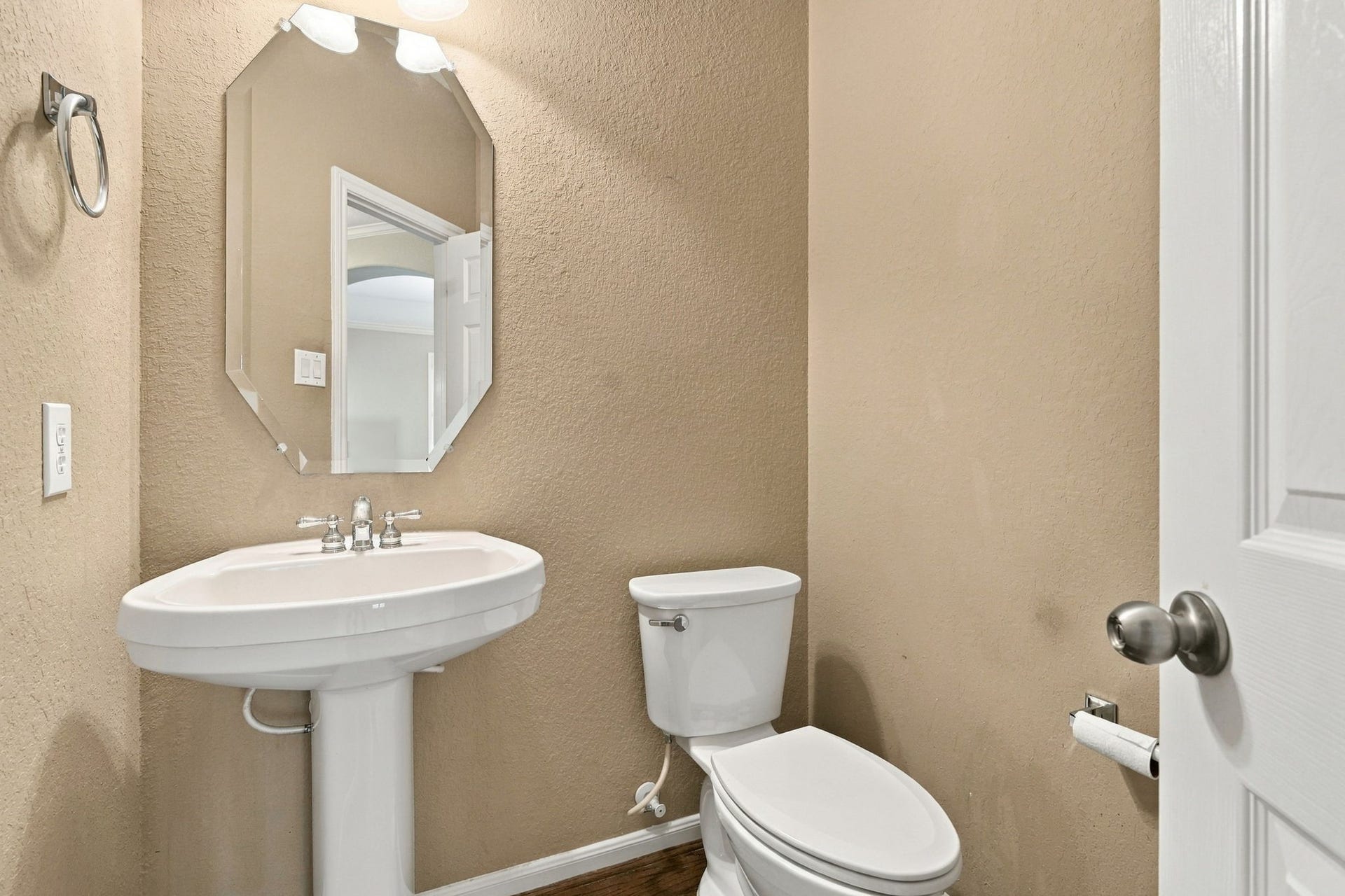 14226 Marin Drive, Cypress, TX 77429 A clean and functional half bath featuring warm neutral walls, and crisp white trim. The space includes a pedestal sink.