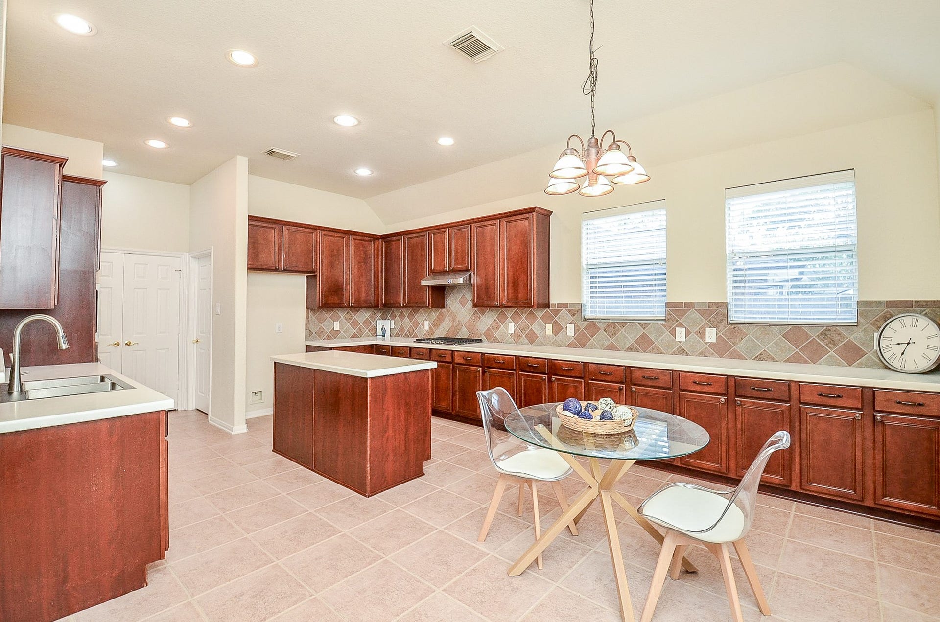 14407 Spanish River Lane, Cypress, TX 77429 No disappearing into the kitchen when everyone else is gathered together. The wide opening keeps the kitchen connected to the family room, while the island provides additional workspace and storage.