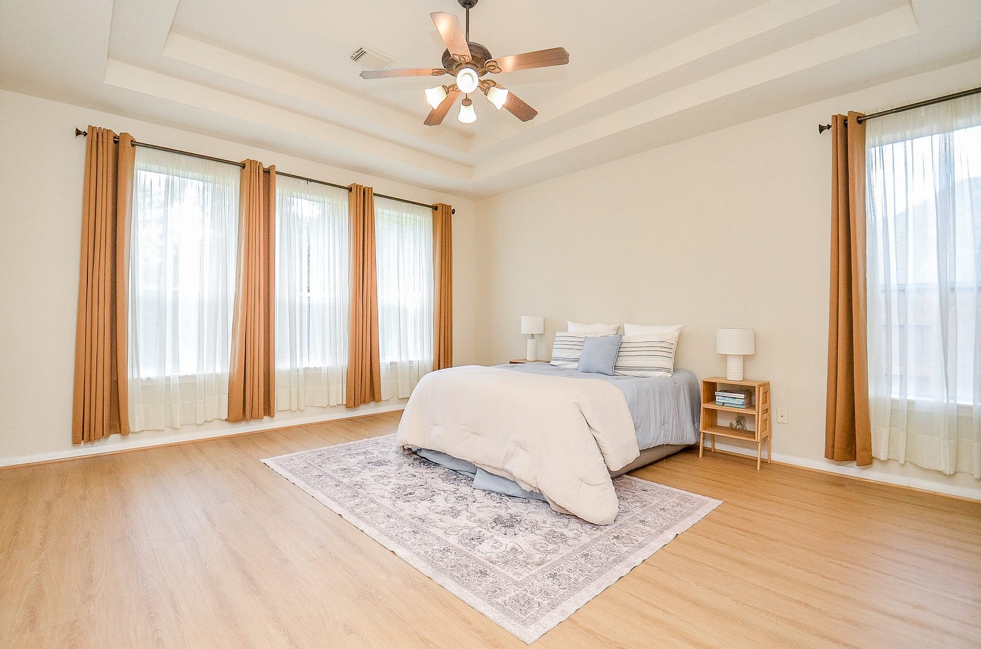 14407 Spanish River Lane, Cypress, TX 77429 A primary suite with room to truly spread out. The tray ceiling adds architectural interest while multiple windows bring in natural light, and the generous proportions leave plenty of space beyond the bed for additional furniture or a sitting area.