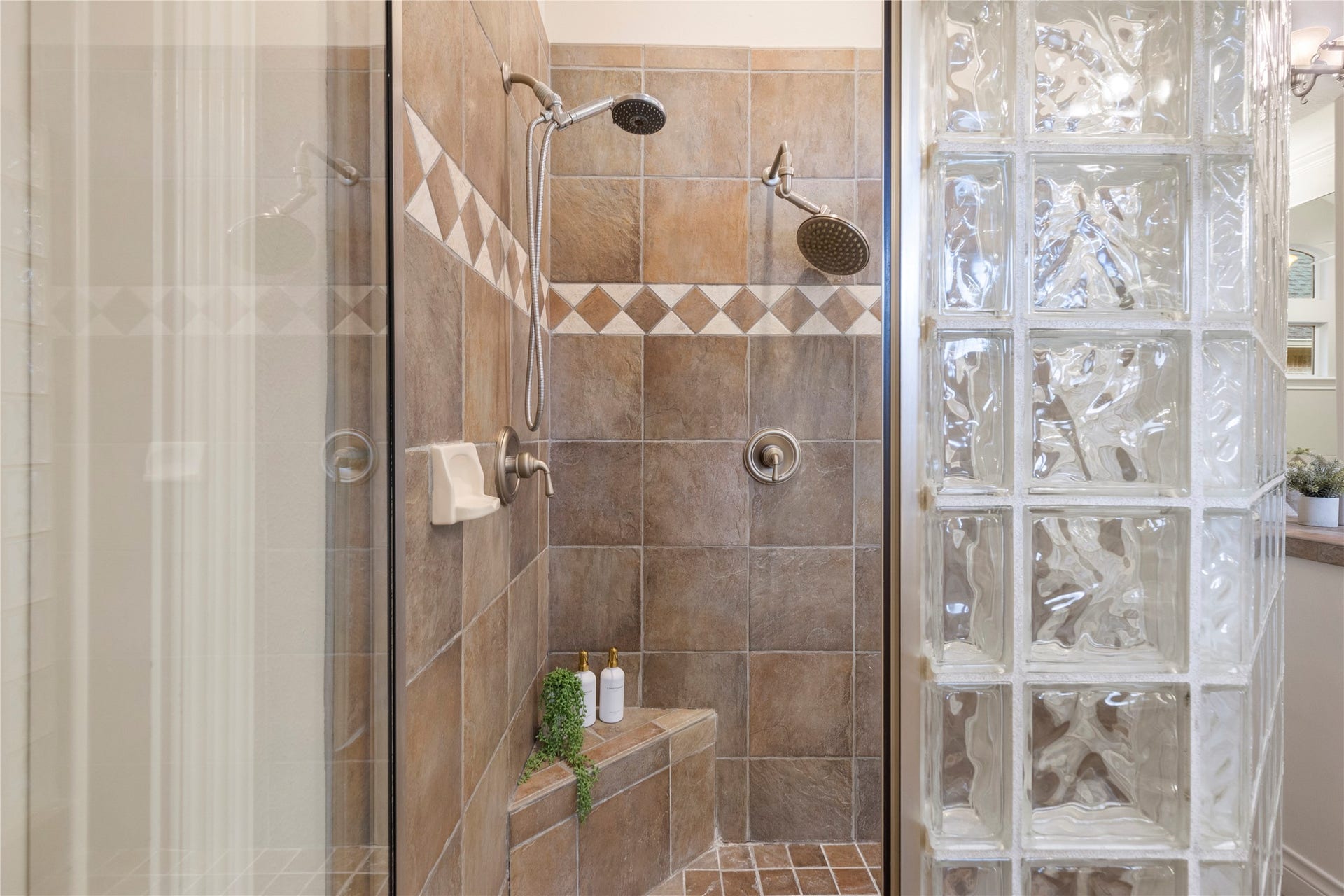 6207 Windrose Hollow Lane, Spring, TX 77379 A separate shower with glass block detail adds function and privacy to the primary bath. The layout supports daily ease while preserving the suites sense of retreat.