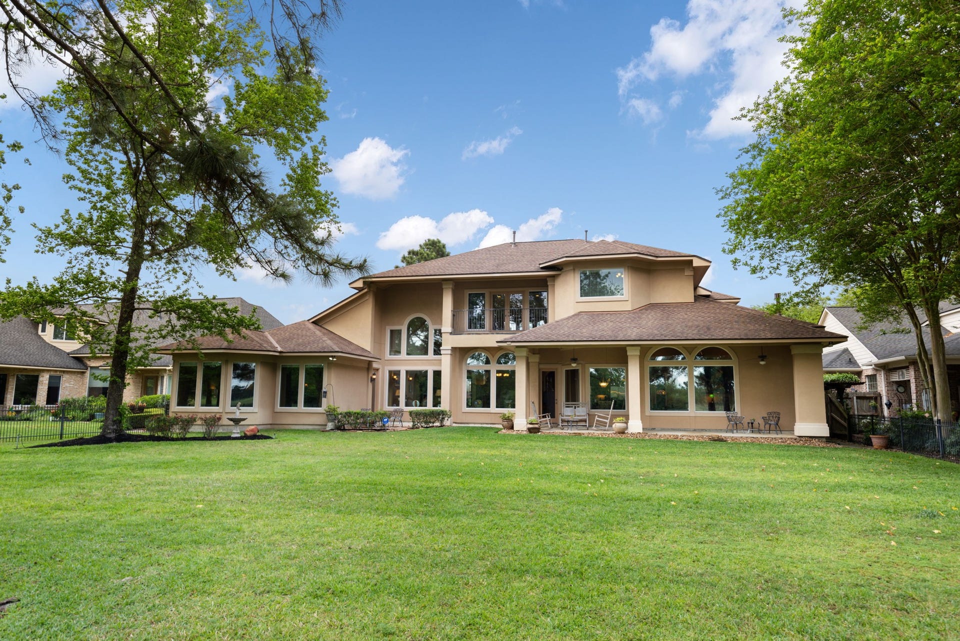 6207 Windrose Hollow Lane, Spring, TX 77379 The rear elevation showcases the homes scale, covered outdoor living, and wide backyard opening to the golf course. The setting feels private, scenic, and rare for this price point.