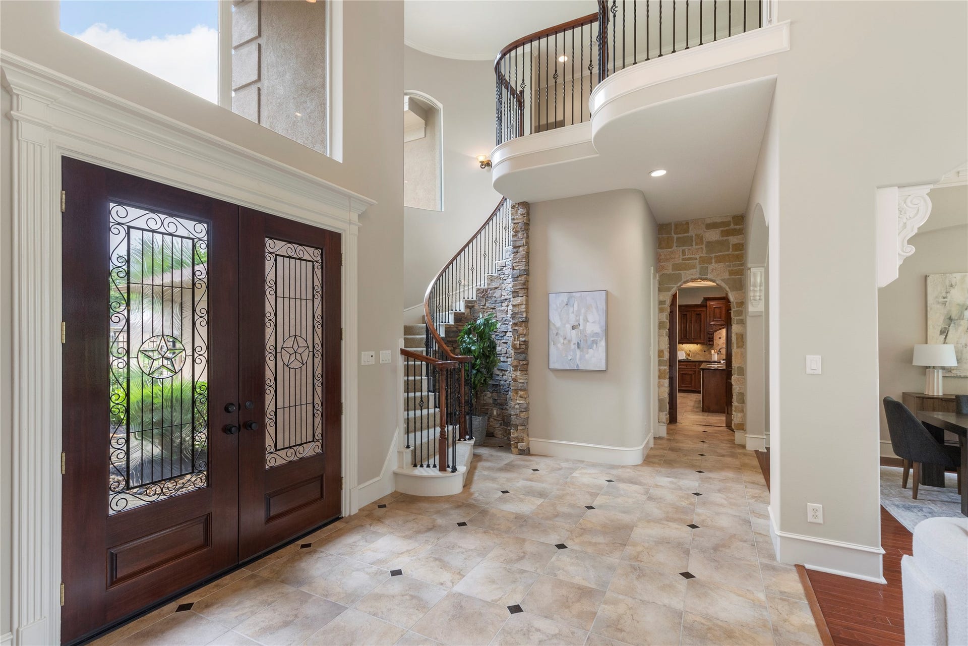 6207 Windrose Hollow Lane, Spring, TX 77379 The curved staircase with wrought iron detail adds architectural presence to the center of the home. A rock accent wall enhances the custom character and gives the foyer a distinctive focal point.