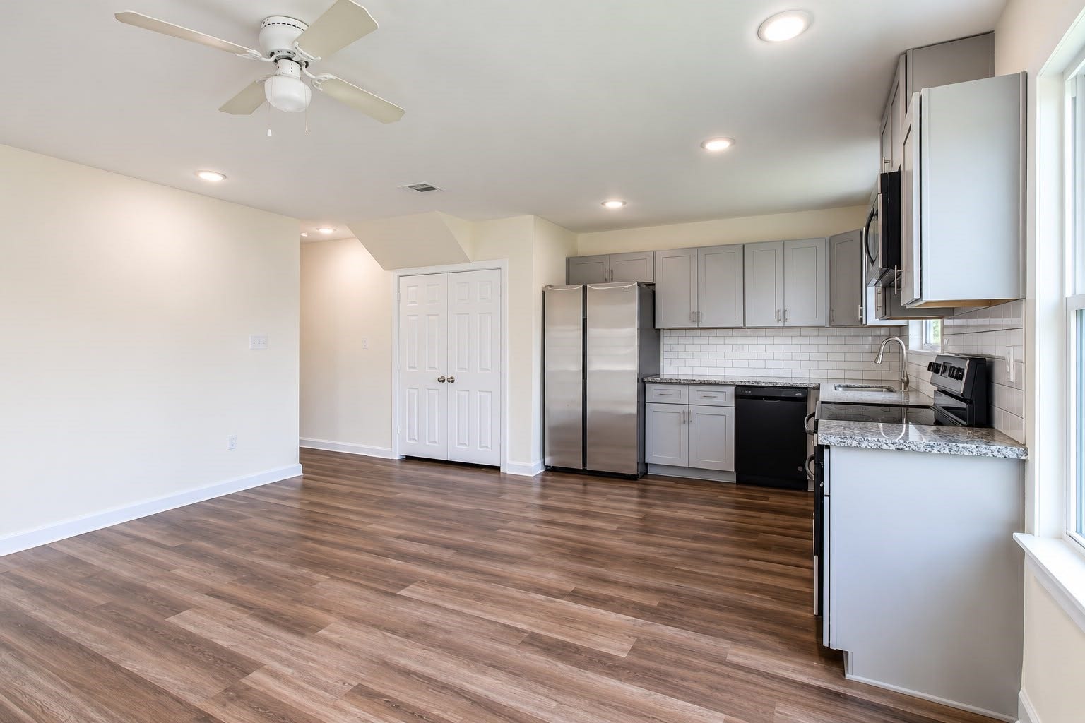 8204 Eastover Street, #A, Houston, TX 77028 Kitchen with stainless steel appliances, gray cabinets, and plenty of counter space, open to the living area.