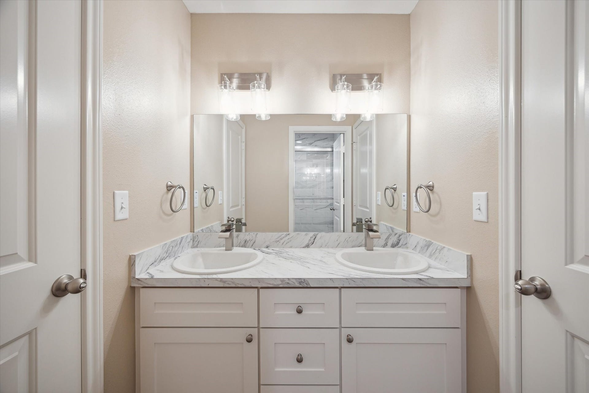 Here is the bath room between the 2 bed rooms.  Notice the double sinks and in the mirror you see the glass in shower.
