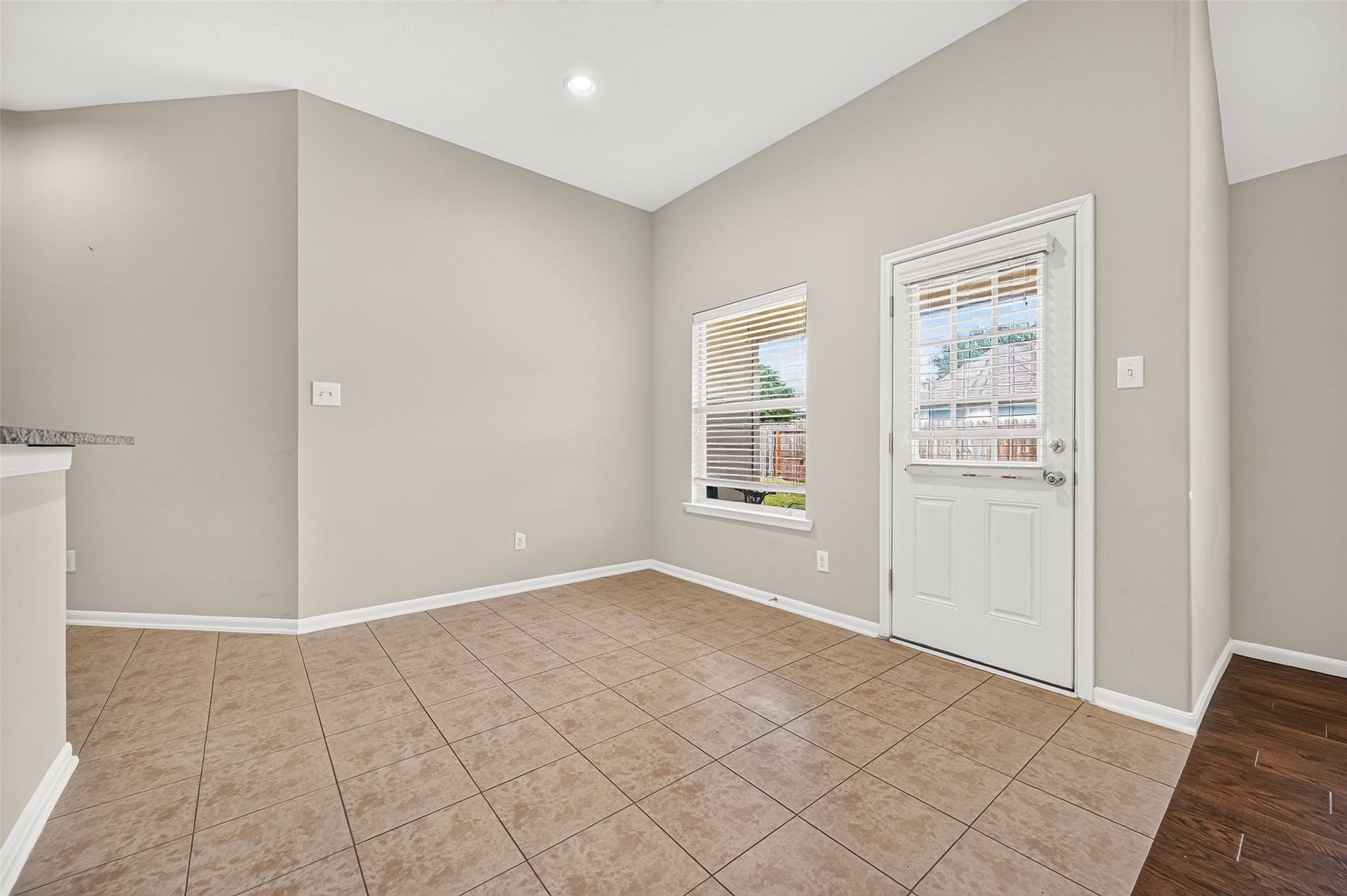 9307 Russeff Field Lane, Rosenberg, TX 77469 Breakfast area featuring neutral tile flooring, arched architectural details, and an open layout connecting to the kitchen.