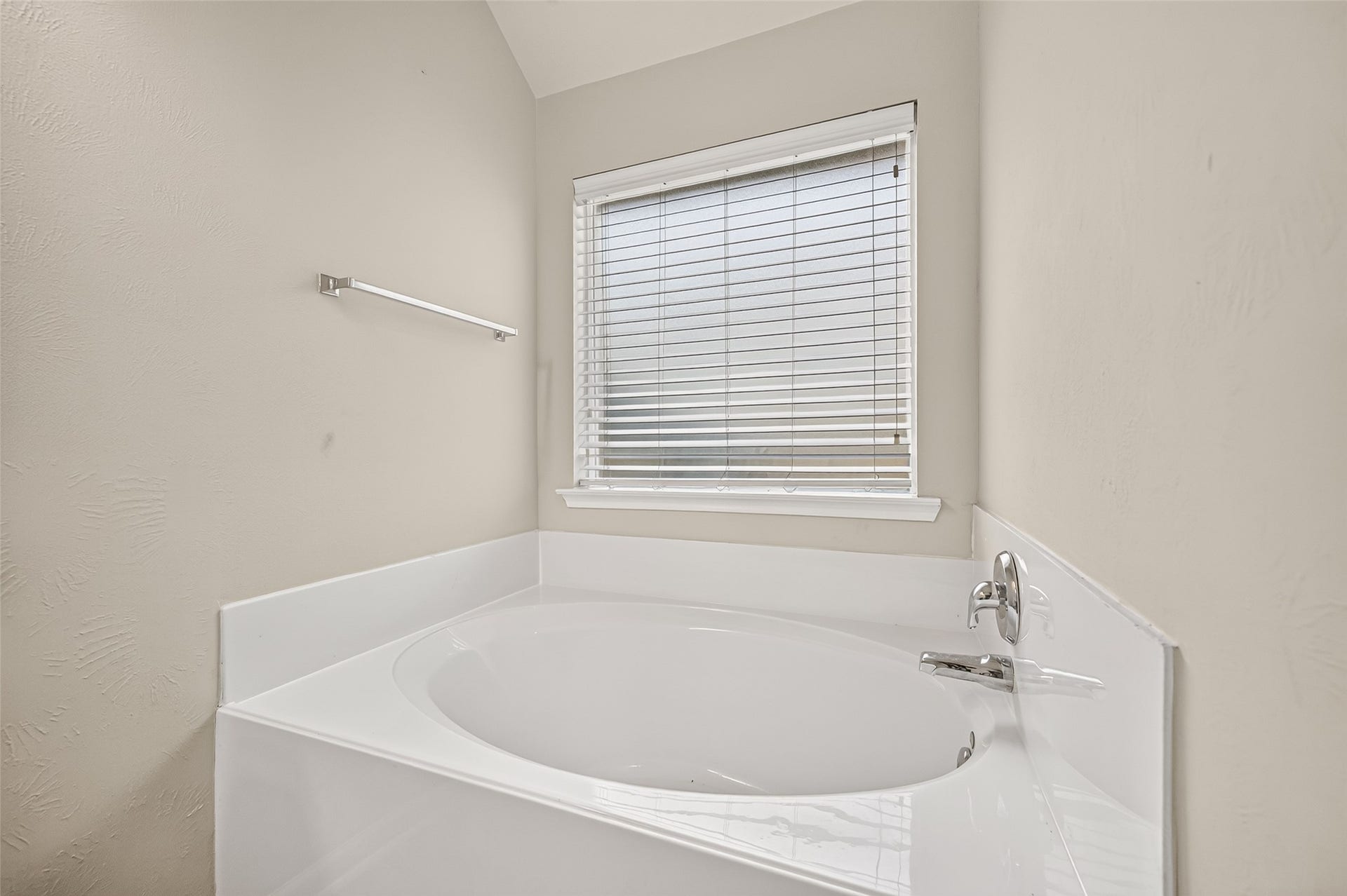 9307 Russeff Field Lane, Rosenberg, TX 77469 Separate soaking tub positioned beneath a window, offering natural light and a relaxing bathroom setting.