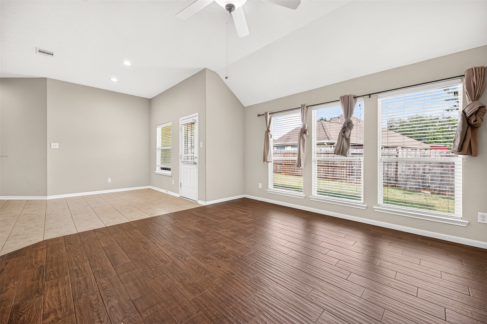 9307 Russeff Field Lane, Rosenberg, TX 77469 Open living area featuring expansive windows overlooking the backyard and rich wood-look flooring.