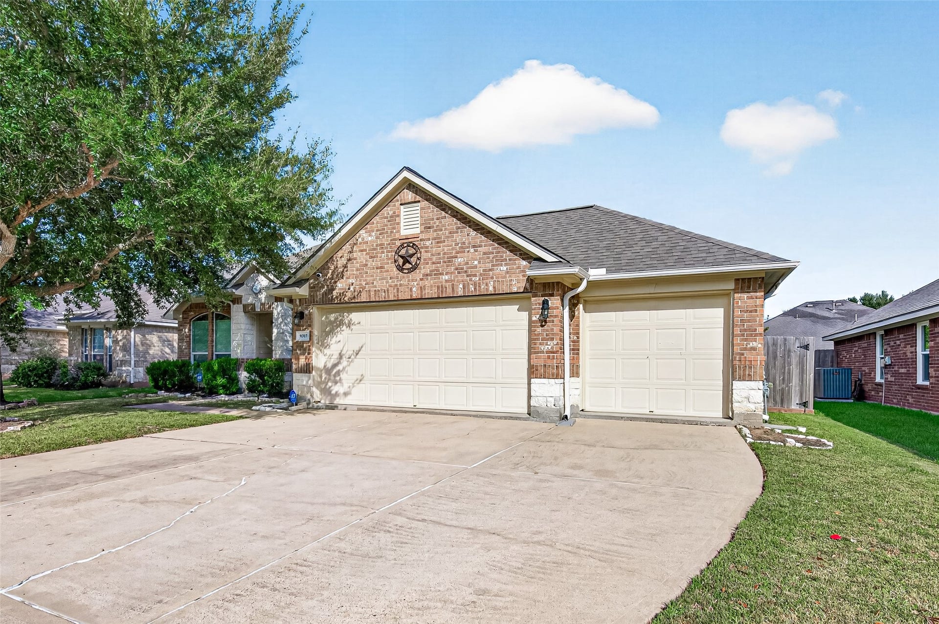 9307 Russeff Field Lane, Rosenberg, TX 77469 Wide front exterior view showcasing the attached two-car garage, extended driveway, and mature shade trees.
