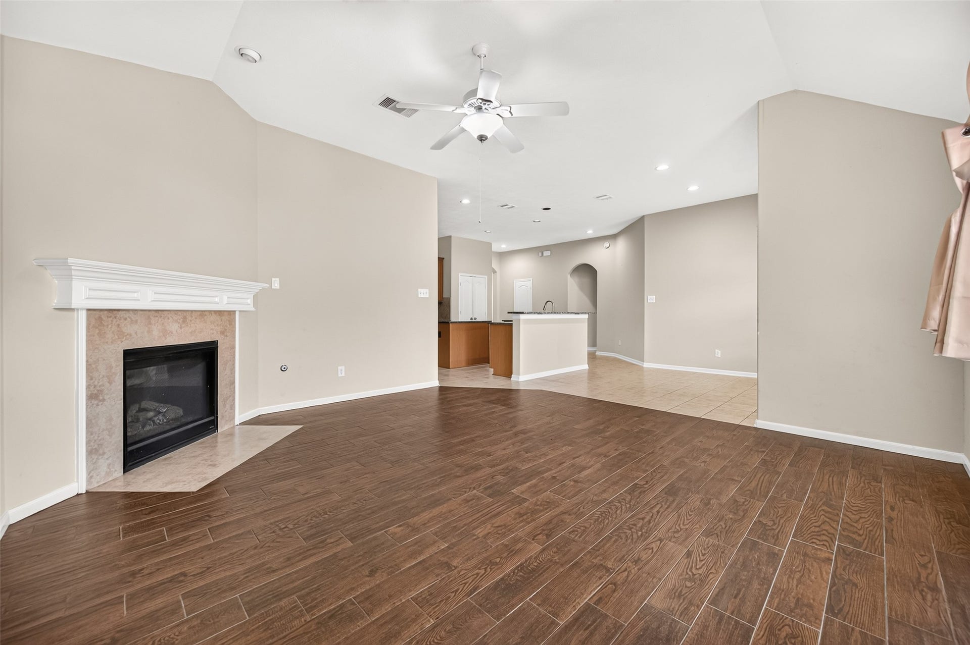 9307 Russeff Field Lane, Rosenberg, TX 77469 Additional living room view showcasing the fireplace, vaulted ceiling, and seamless connection to the kitchen.