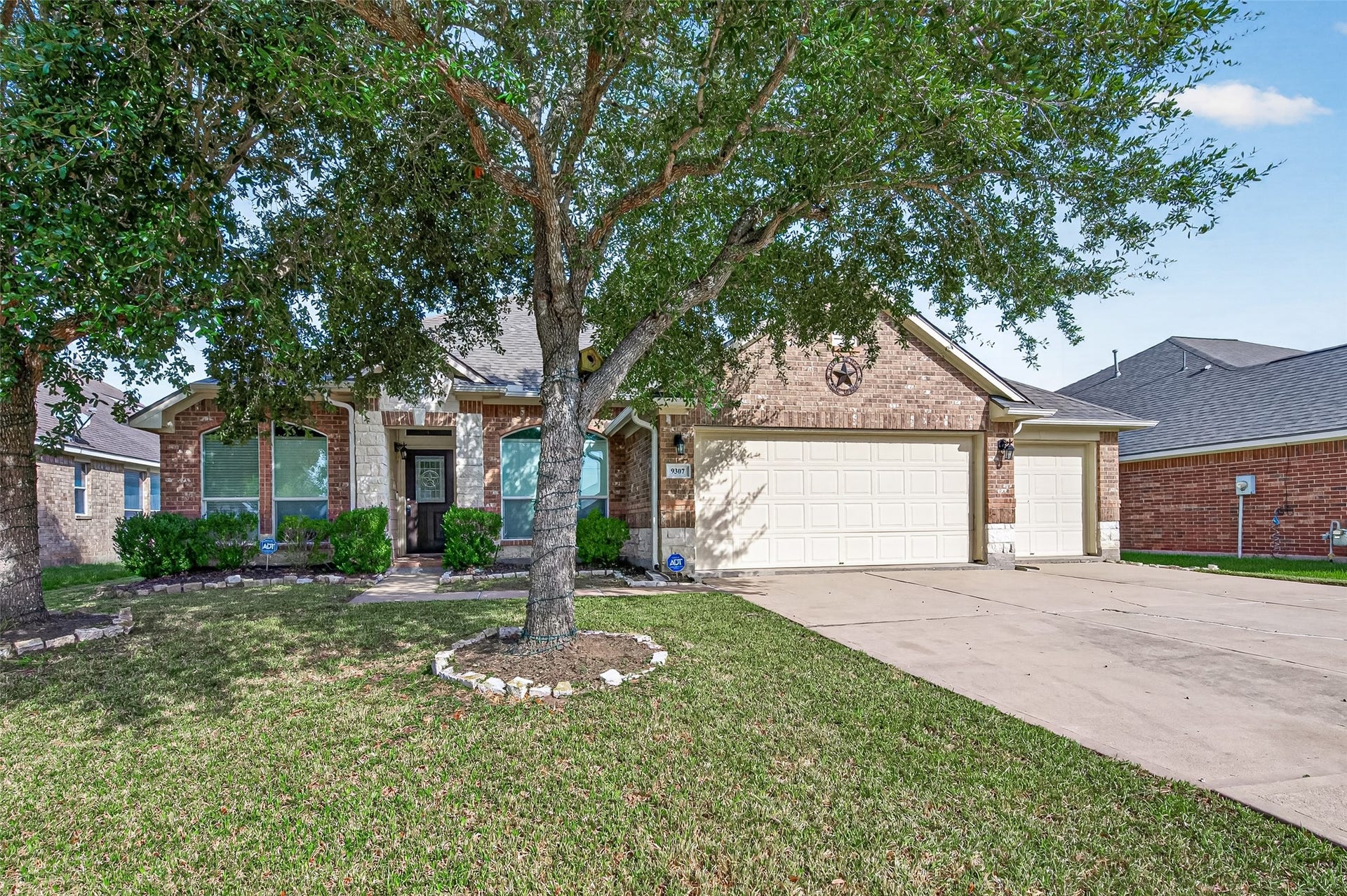 9307 Russeff Field Lane, Rosenberg, TX 77469 Front exterior featuring brick construction, mature landscaping, and an arched covered entrance.