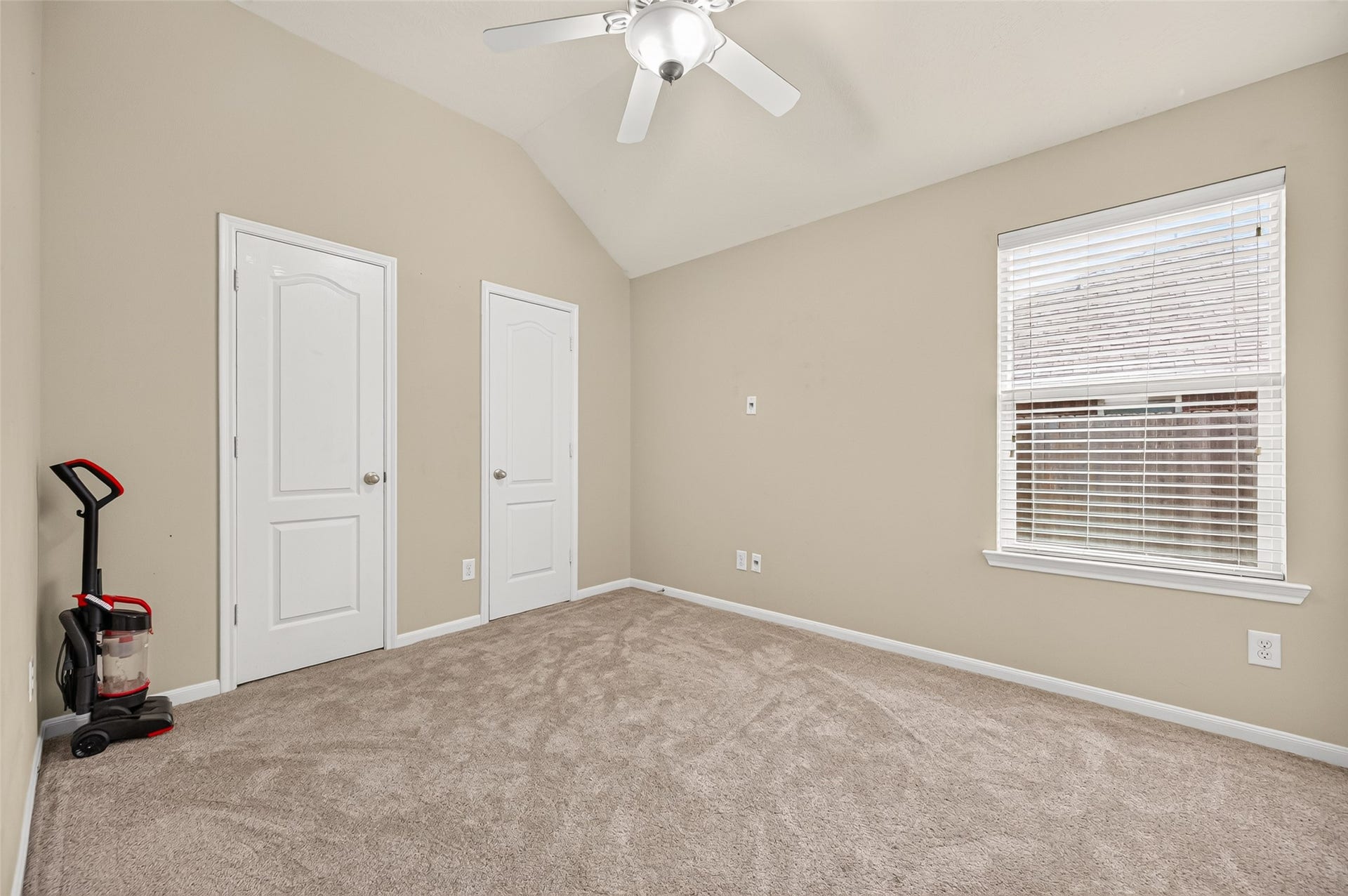 9307 Russeff Field Lane, Rosenberg, TX 77469 Secondary bedroom featuring a vaulted ceiling, neutral carpeting, and convenient access to the hallway