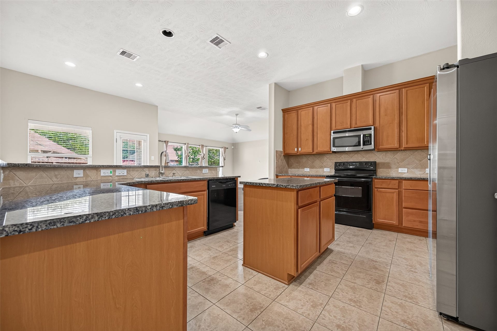 9307 Russeff Field Lane, Rosenberg, TX 77469 Additional kitchen perspective highlighting the cabinetry, center island, and bright adjoining space.