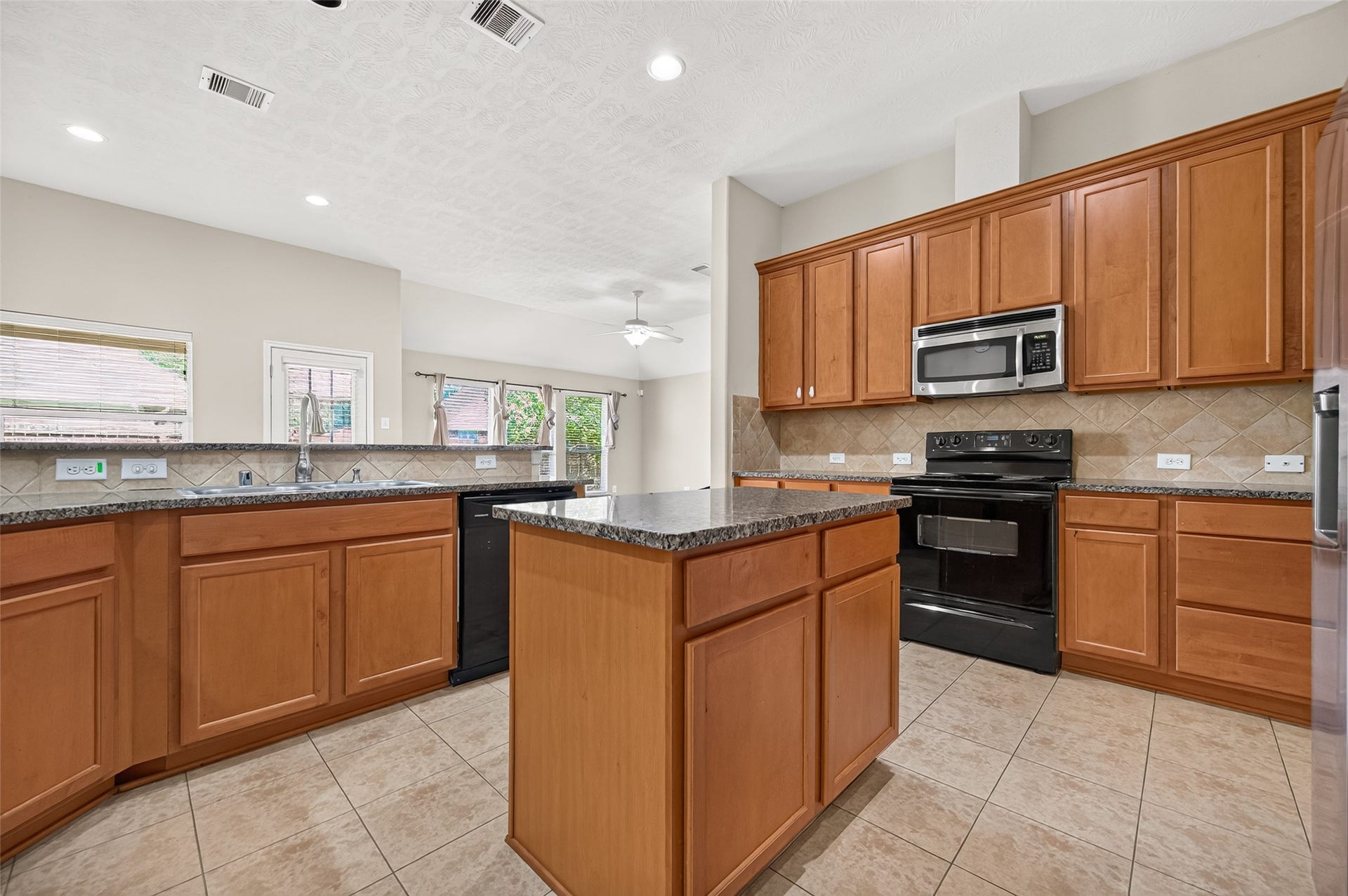 9307 Russeff Field Lane, Rosenberg, TX 77469 Wide kitchen view showcasing the functional layout, center island, and connection to the surrounding areas.