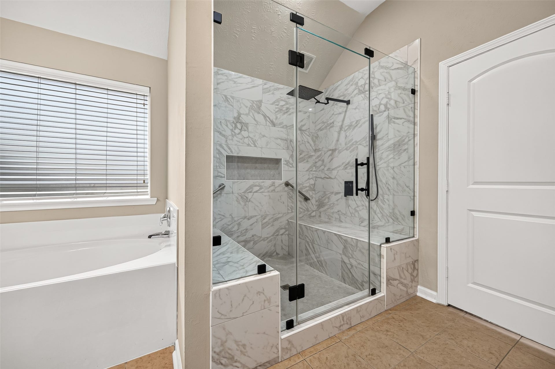 9307 Russeff Field Lane, Rosenberg, TX 77469 Primary bathroom showcasing the separate soaking tub, glass-enclosed shower, and tiled walls.