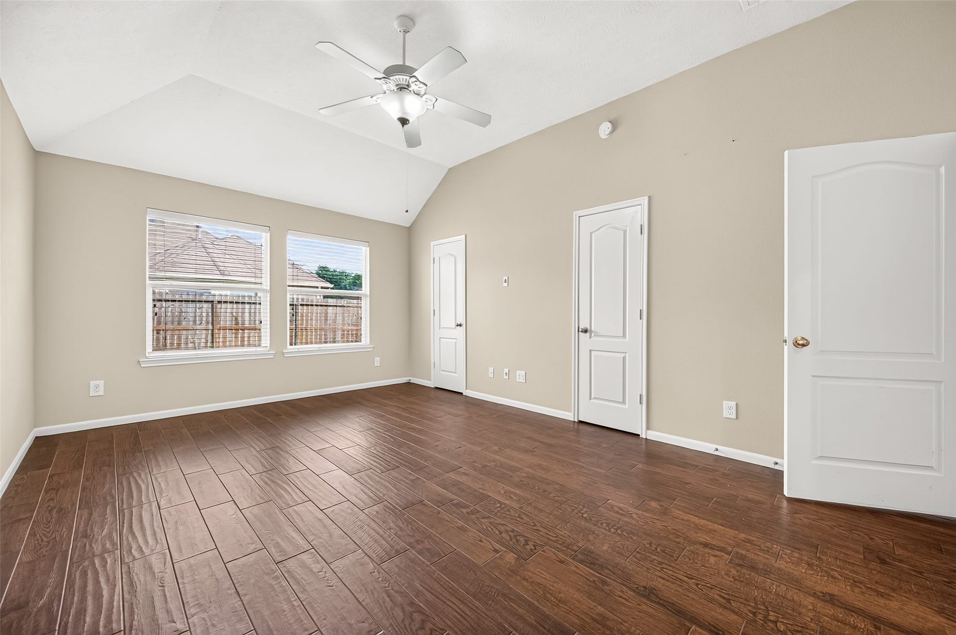 9307 Russeff Field Lane, Rosenberg, TX 77469 Additional view of the primary bedroom showcasing the wood-look flooring, neutral walls, and backyard-facing windows.