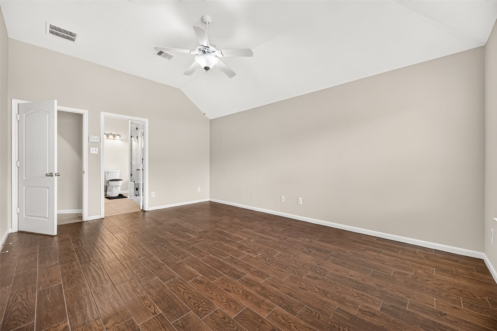 9307 Russeff Field Lane, Rosenberg, TX 77469 Another view of the primary bedroom highlighting its spacious layout, neutral finishes, and vaulted ceiling.