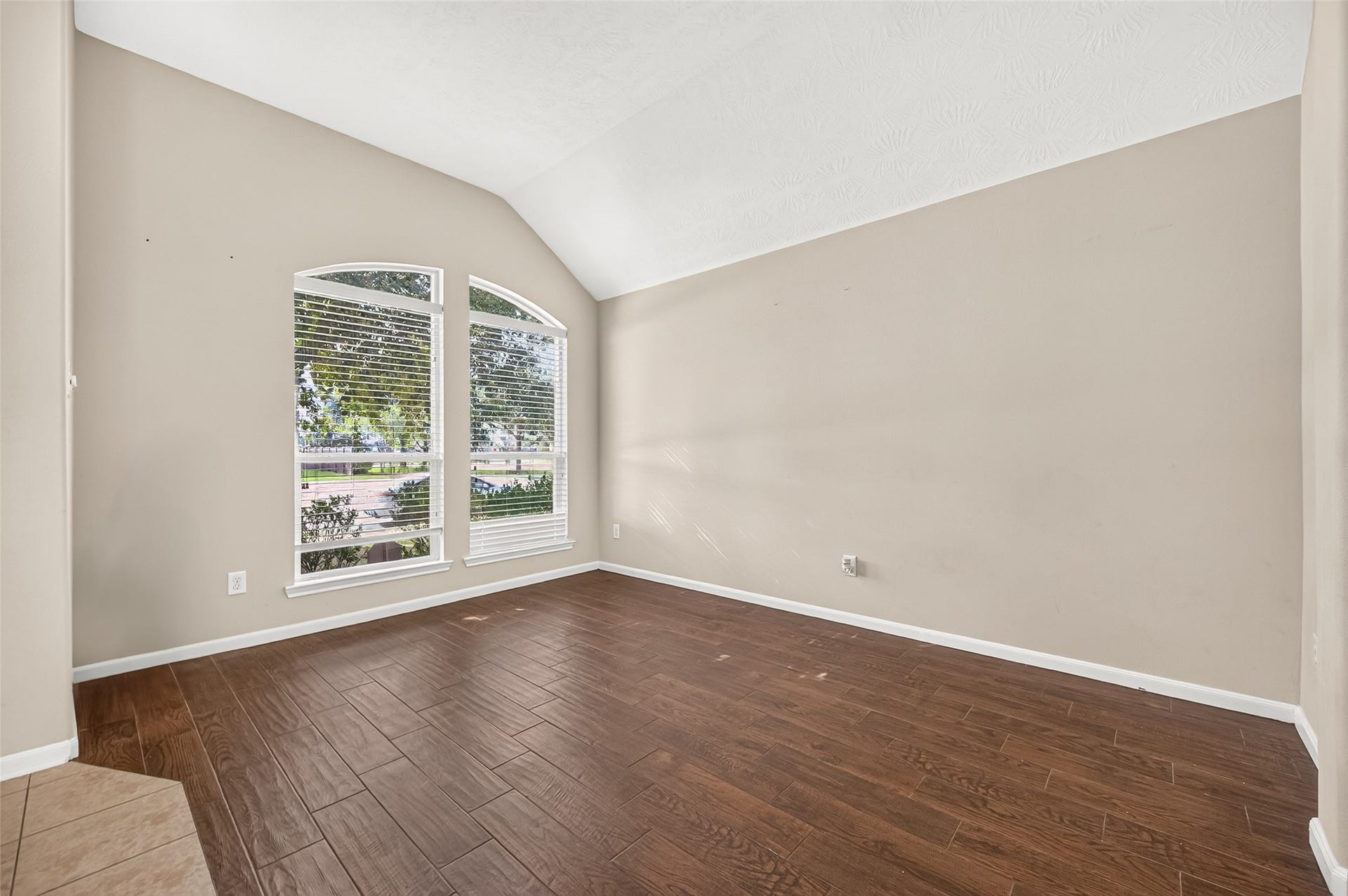 9307 Russeff Field Lane, Rosenberg, TX 77469 Versatile flex area featuring wood-look flooring, arched windows, and neutral walls, suitable for a variety of uses.