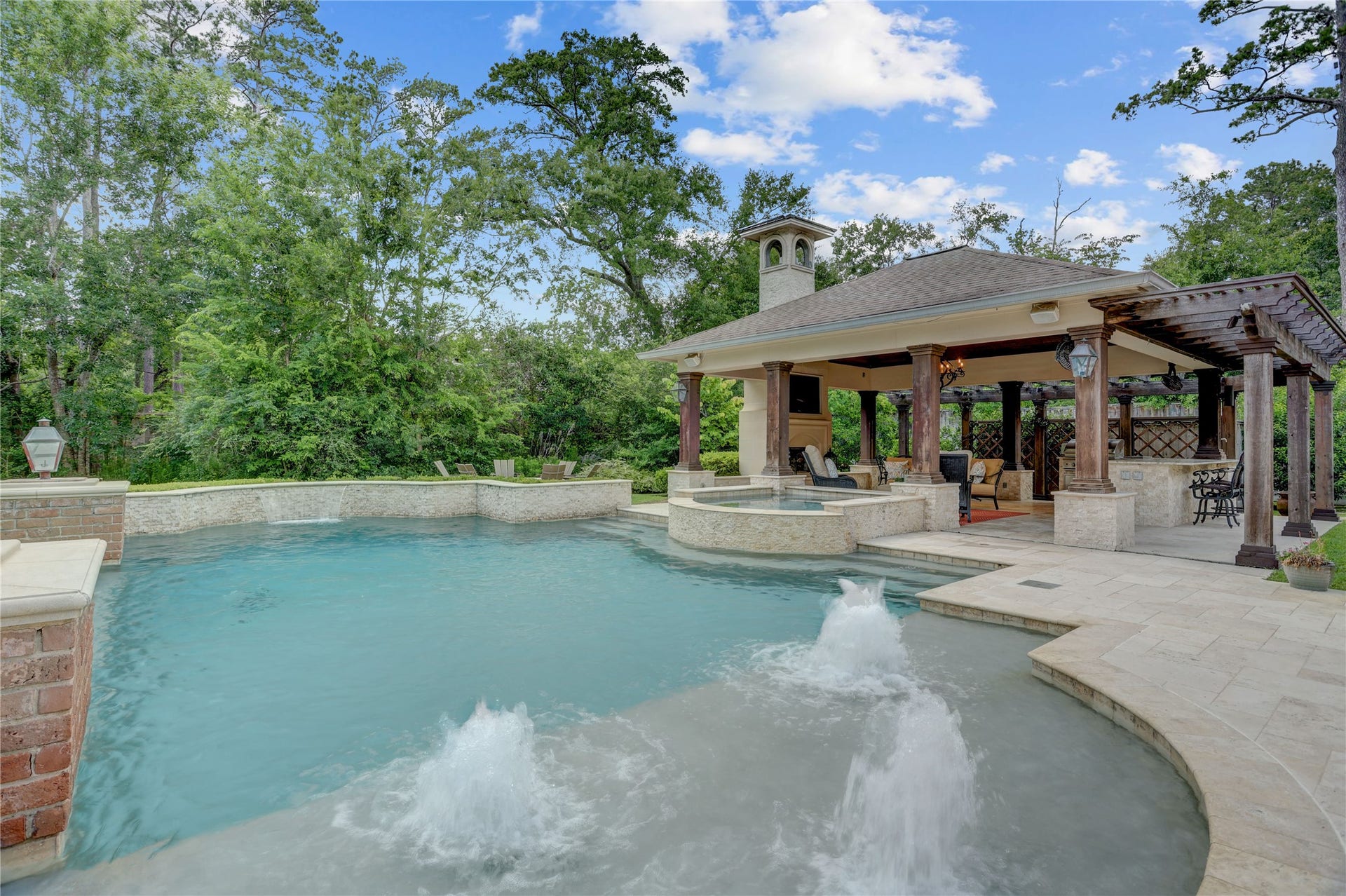The pool with multiple water features has a chiller for those hot Houston days