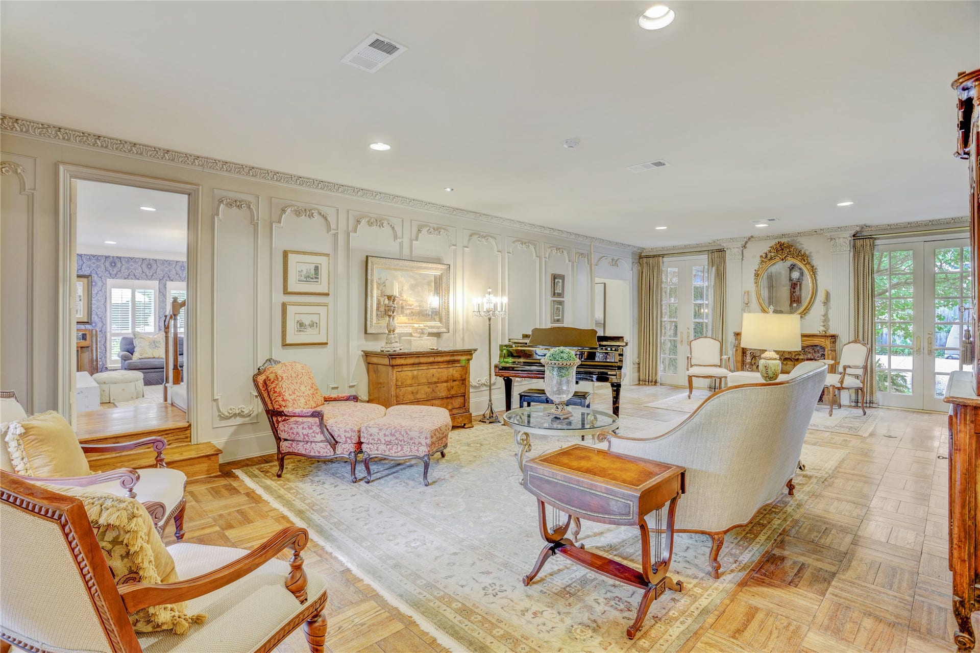 The formal living room, with parquet floors, lovely Louis V paneling and Pierre Deux draperies, the fireplace has a marble surround and French carved mantle